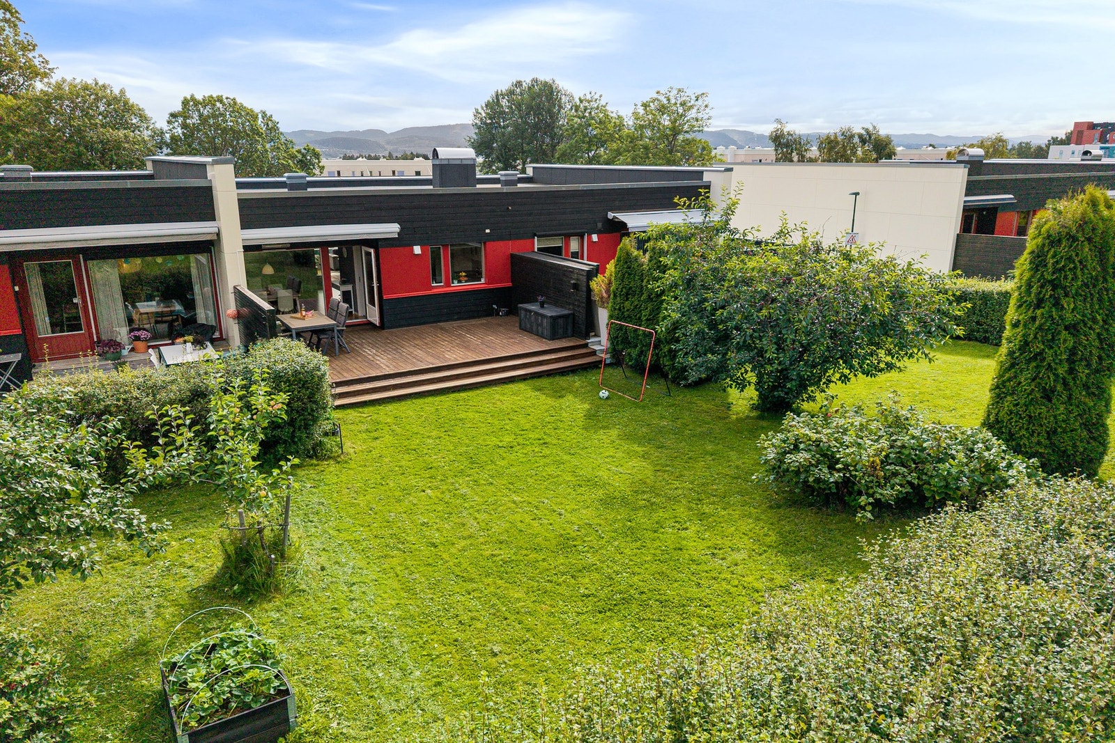 Velholdt og skjermet uteområde med stor plen, terrasse og pent opparbeidede grøntarealer. Galleribilde