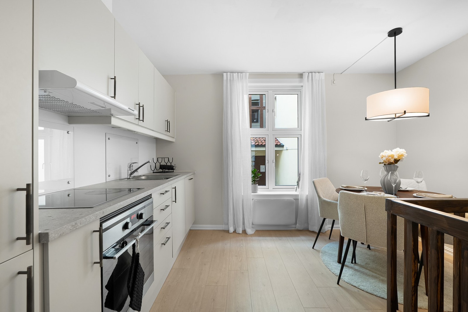 Innredningen har benke-/ og overskap, slette fronter og laminerte benkeplater. Over vask og platetopp er det montert to plater av herdet glass . Galleribilde