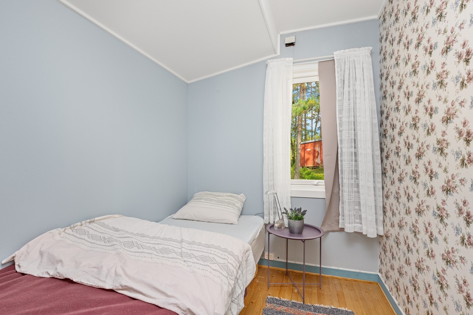 Rommet har plass til enkeltseng og møblering, med vegger kledd i malt tapet og panel. Galleribilde