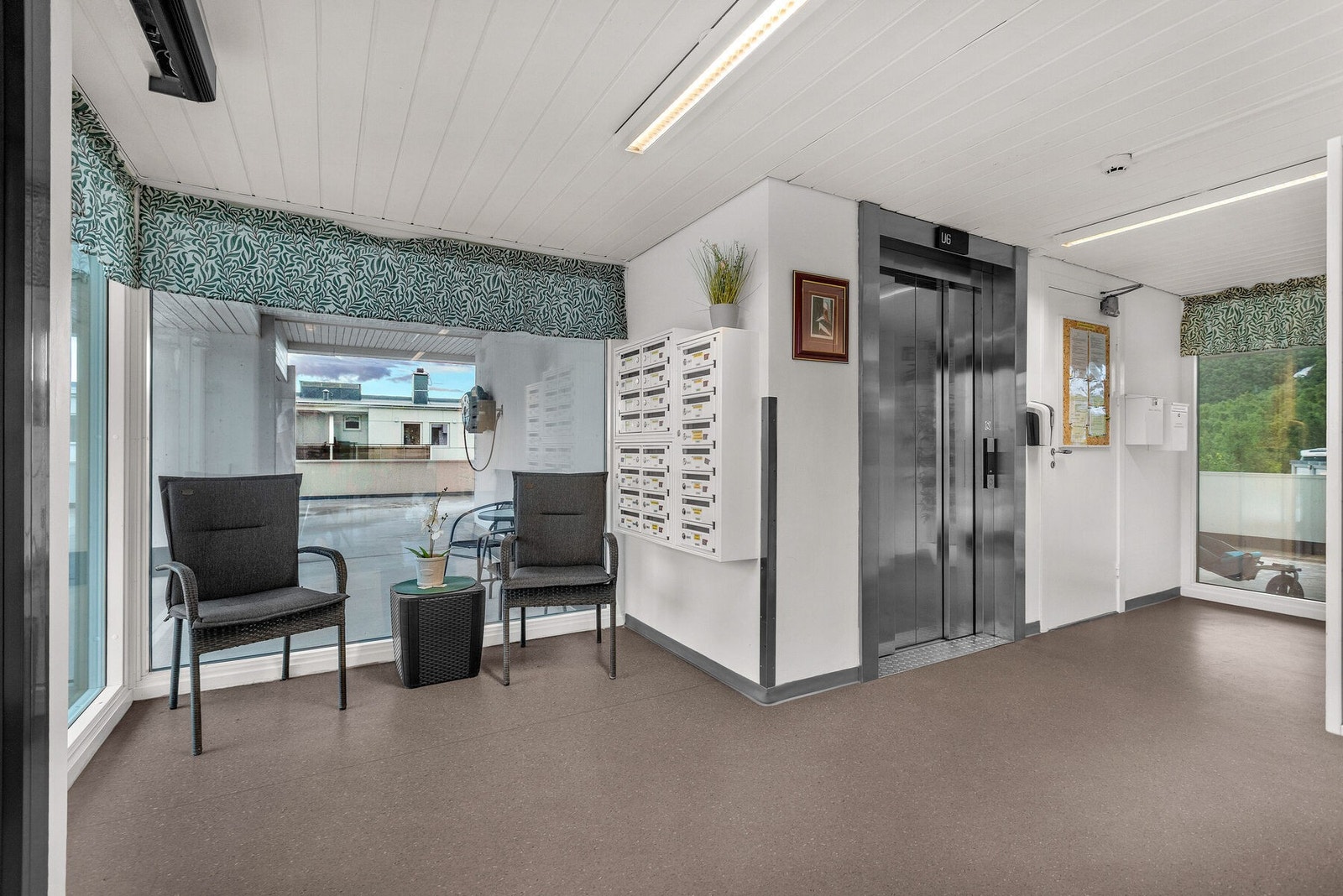 Lyst og innbydende fellesareal med heis og postkasser. Galleribilde