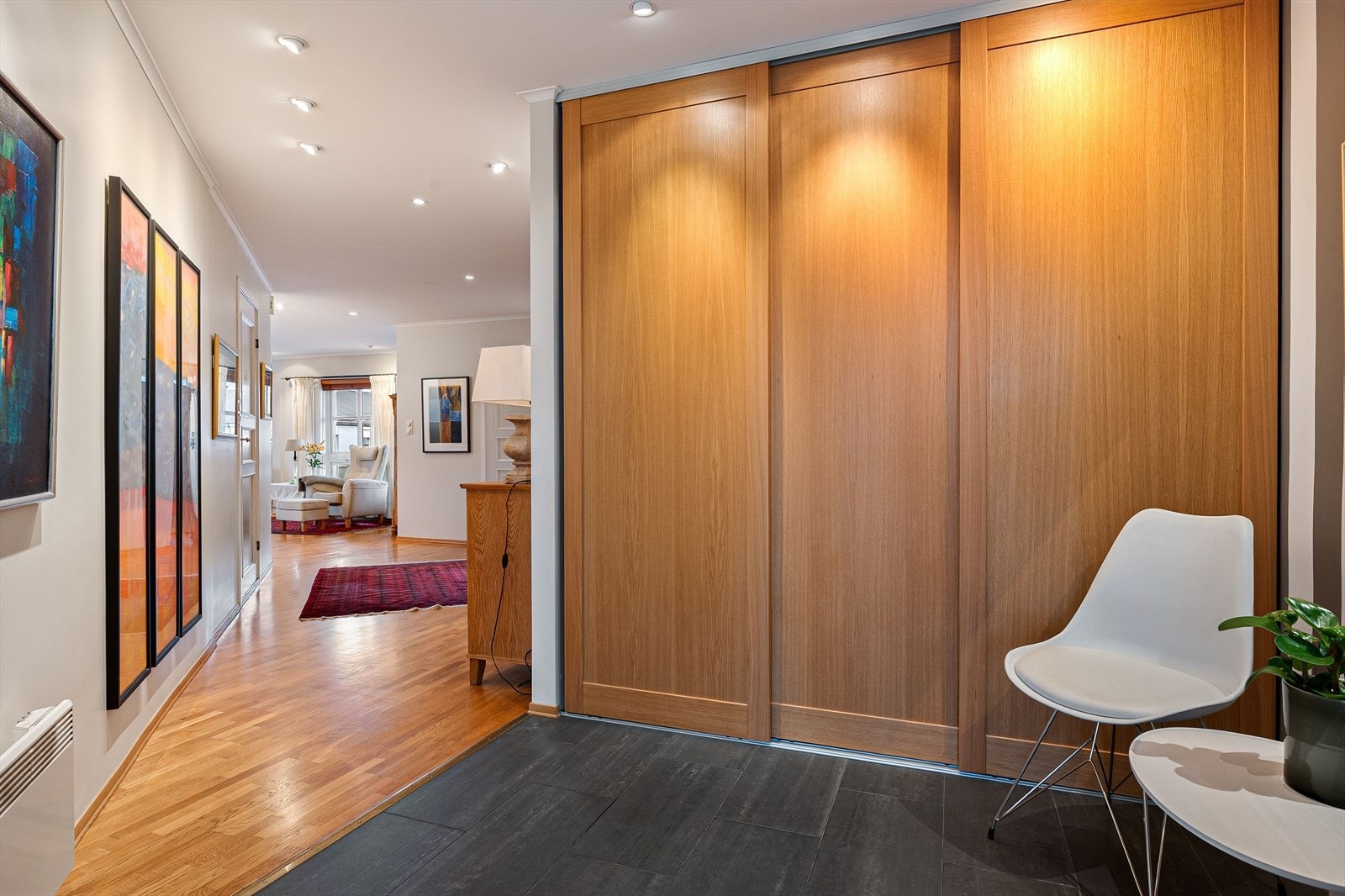 Flott og innbydende gang med flislagt gulv og plassrik skyvedørsgarderobe til yttertøy og sko. Galleribilde