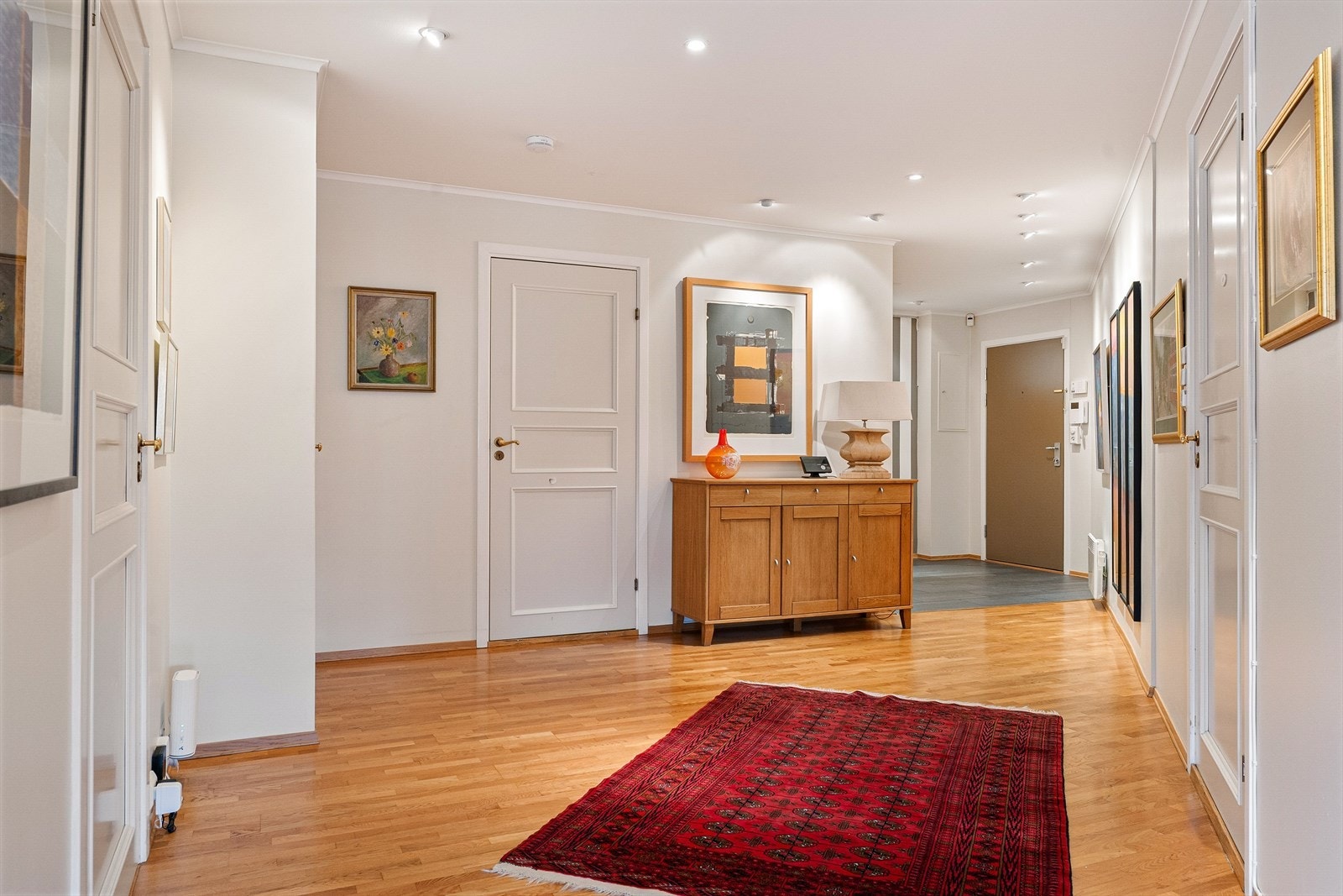I gangen er det fliser på gulv og videre innover i hallområdet er det parkett og plass til frittstående gangmøbel. Galleribilde