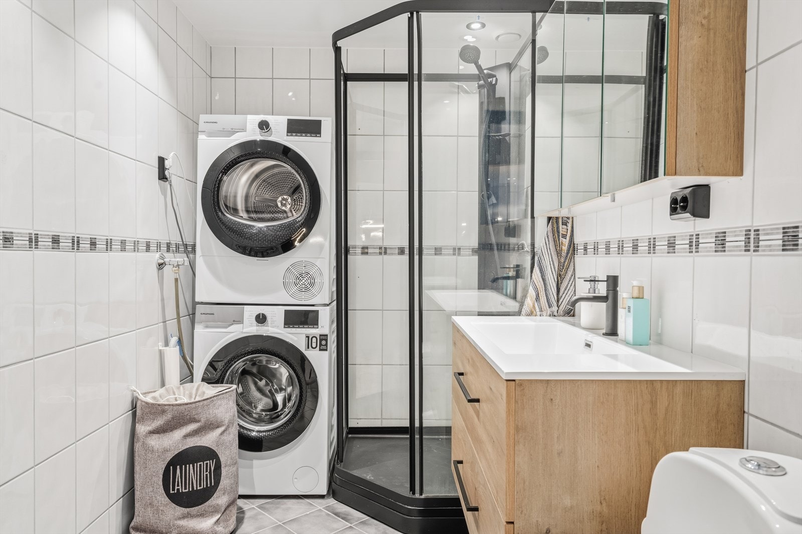 Flislagt bad med elektriske varmekabler i gulvet og opplegg for vaskemaskin. Galleribilde
