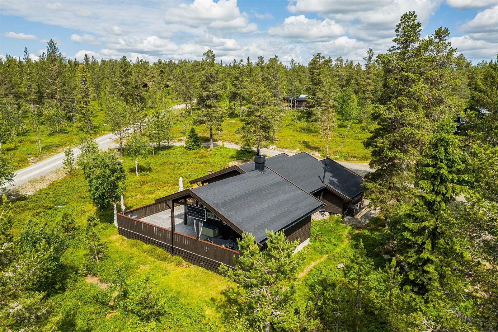 Solcelleanlegg med solcellepanel på konstruksjon/gavlvegg ved terrasse. Innvendig anlegg med batteri, og veggpaneler. Galleribilde