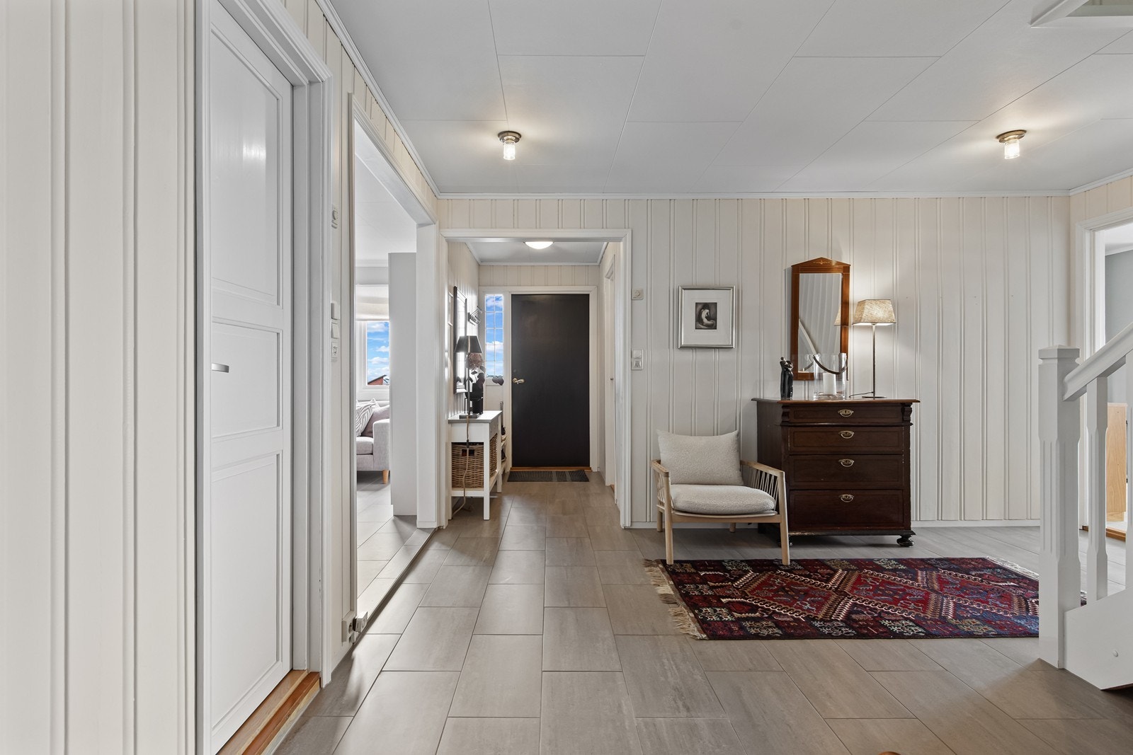 Romslig, flislagt mellomgang med god plass til oppbevaring Galleribilde