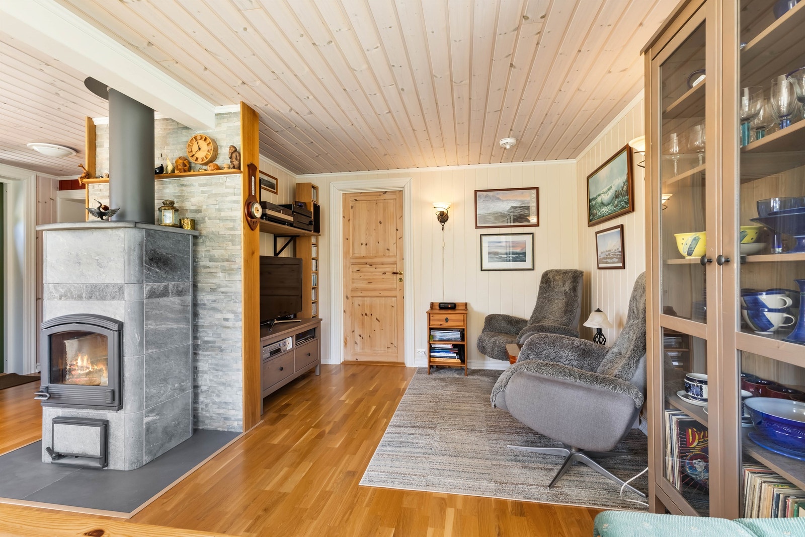 Stålpipen og ildstedet i stuen er fra tilbygget i 2018/2019. Klebersteinsovn som gir god varme. Galleribilde