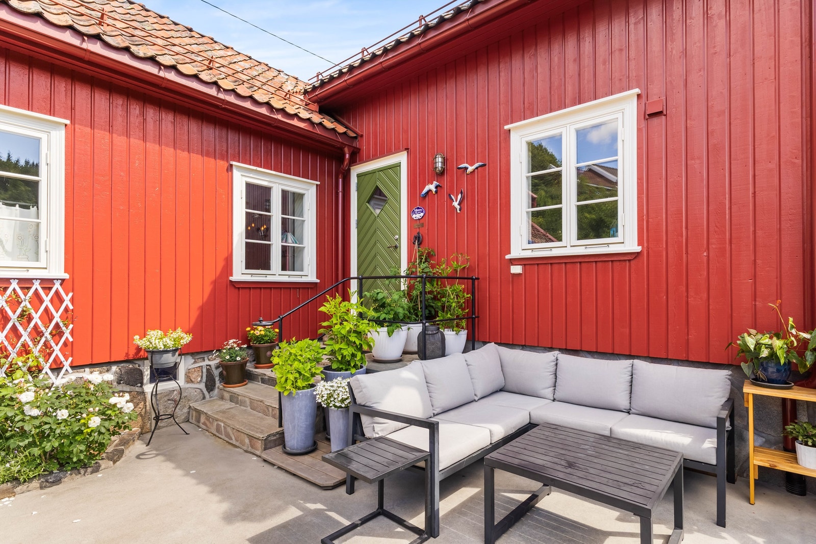 En lun og usjenert uteplass ved et av boligens inngangspartier. Galleribilde