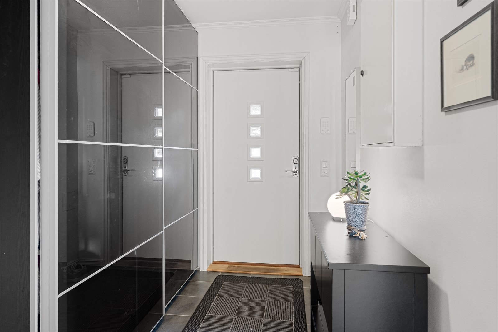 Velkommen inn til entré med flislagt gulv og stor skyvedørsgarderobe Galleribilde