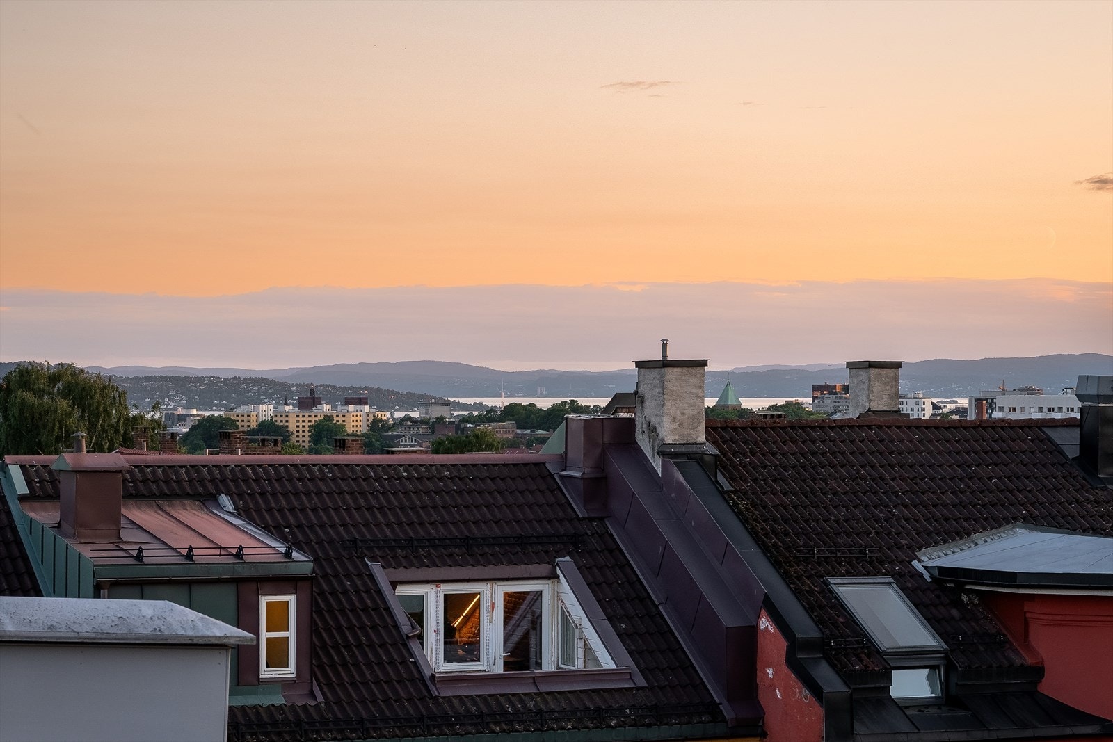 Fra hemsen har man også utsikt over nærliggende hustak med et lite fjordgløtt i det fjerne Galleribilde