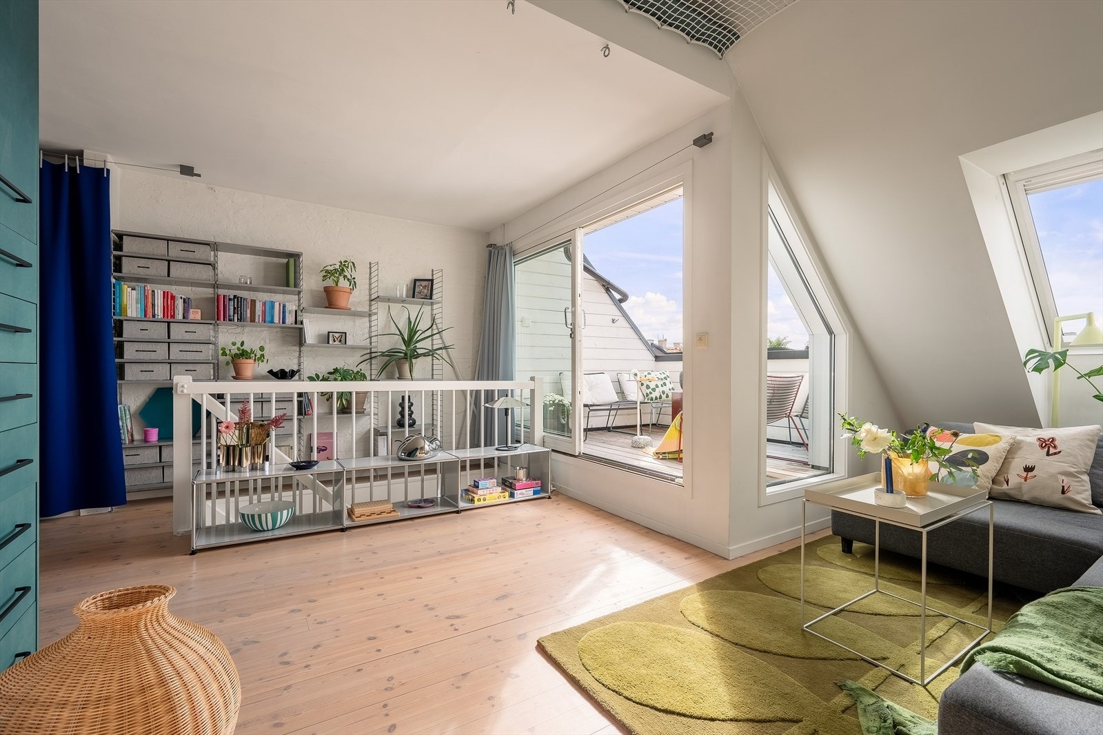Når man beveger seg videre opp trappen til loftsetasjen, kommer man til en lys og romslig stue, hvor noe av leiligehetens særpreg åpenbarer seg Galleribilde