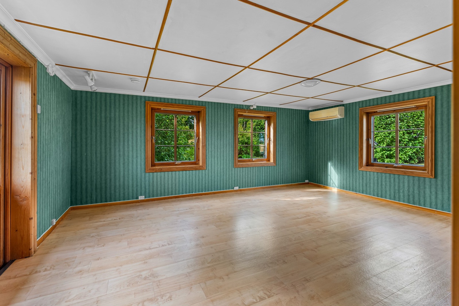Fra denne vinkelen kommer rommets gode størrelse ytterligere frem. De mange vinduene gir nær kontakt med den frodige hagen utenfor, mens den åpne gulvflaten gir stor frihet ved fremtidig innredning. Galleribilde