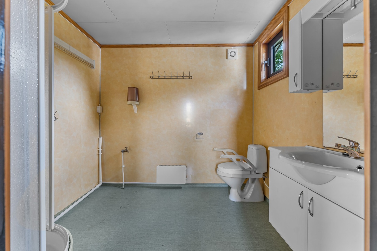 Badet er innredet med toalett, servant med underskap og dusjløsning. Rommet har eldre standard og må sees i sammenheng med boligens generelle behov for modernisering. Galleribilde