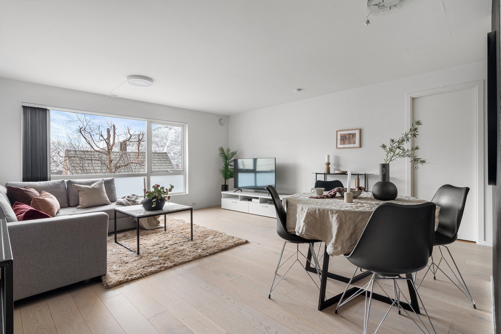 Romslig stue med god plass for innredning av både sofagruppe og spisebord.