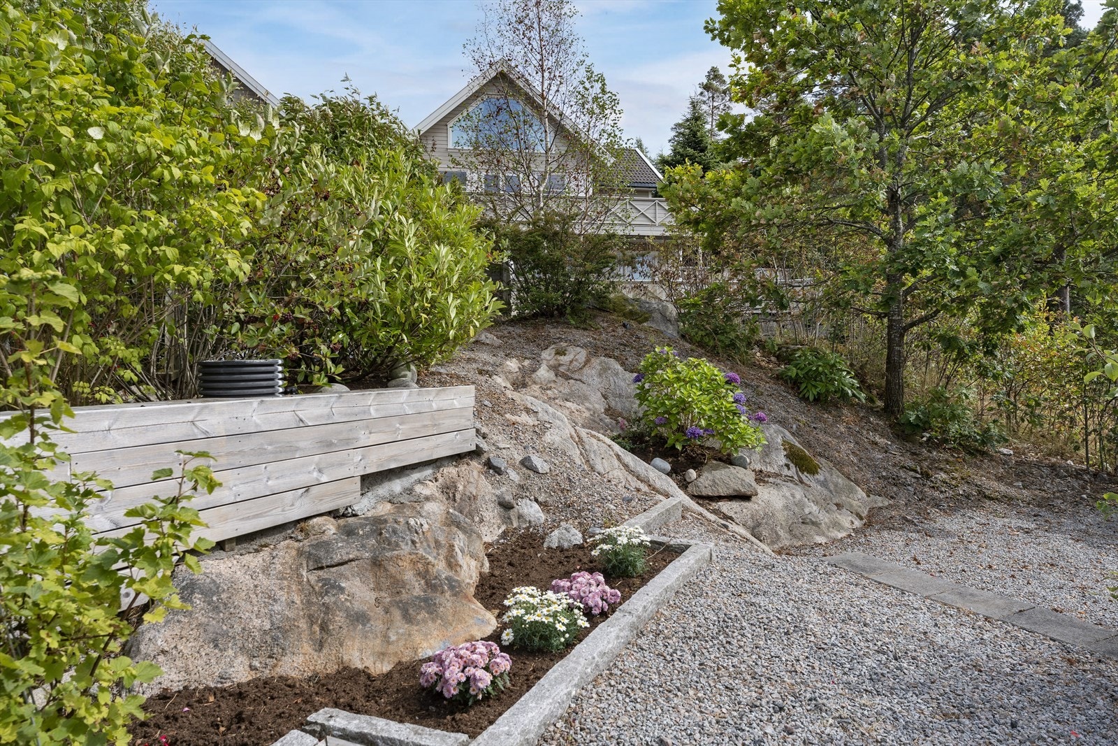 Tomten er pent opparbeidet med bed og beplantning Galleribilde