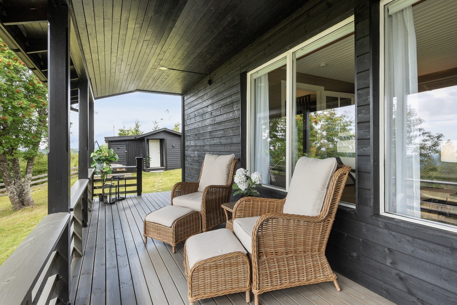 Delvis overbygget veranda med plass for møblering. Galleribilde