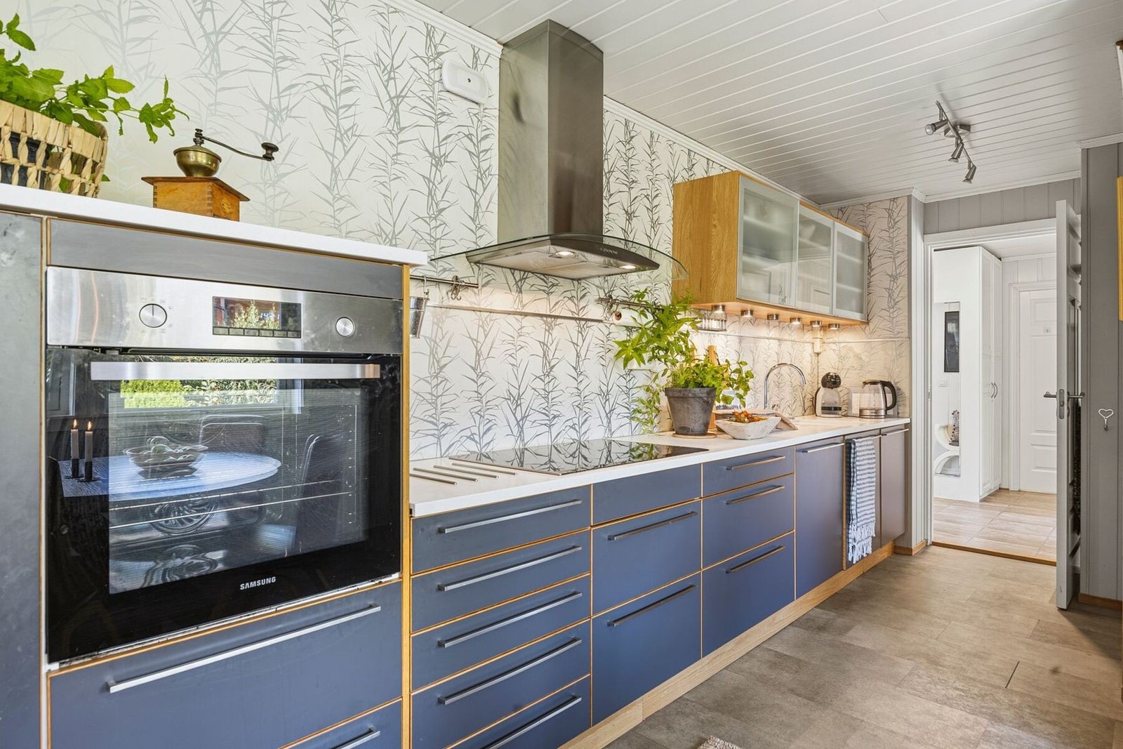 Kjøkkenet har en moderne og stilren innredning med glatte fronter og benkeplate i Corian. Galleribilde