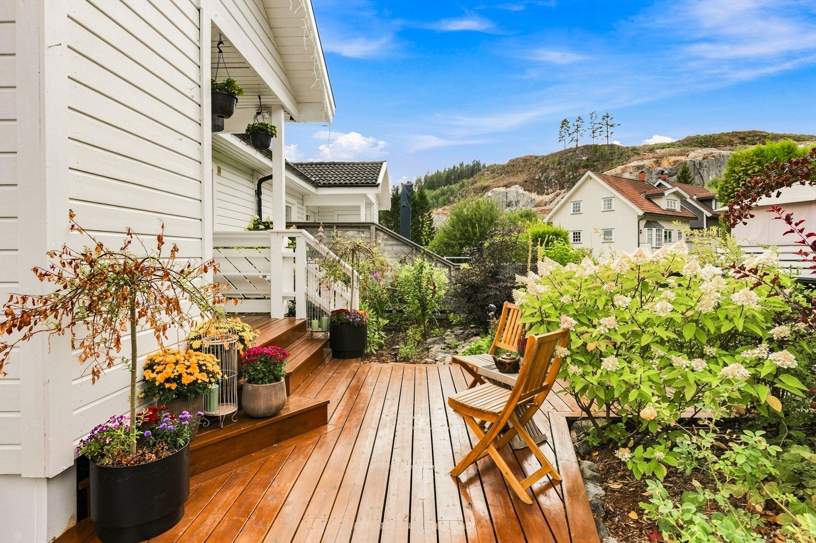 Hyggelig uteområde med terrasse og frodig beplantning - en lun plass for morgenkaffen eller rolige sommerdager. Galleribilde