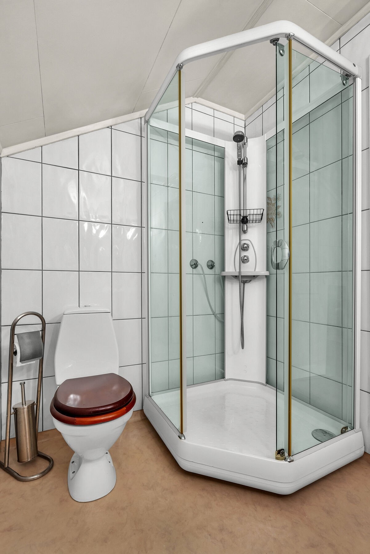 Badet er innredet med dusjkabinett og toalett. Galleribilde
