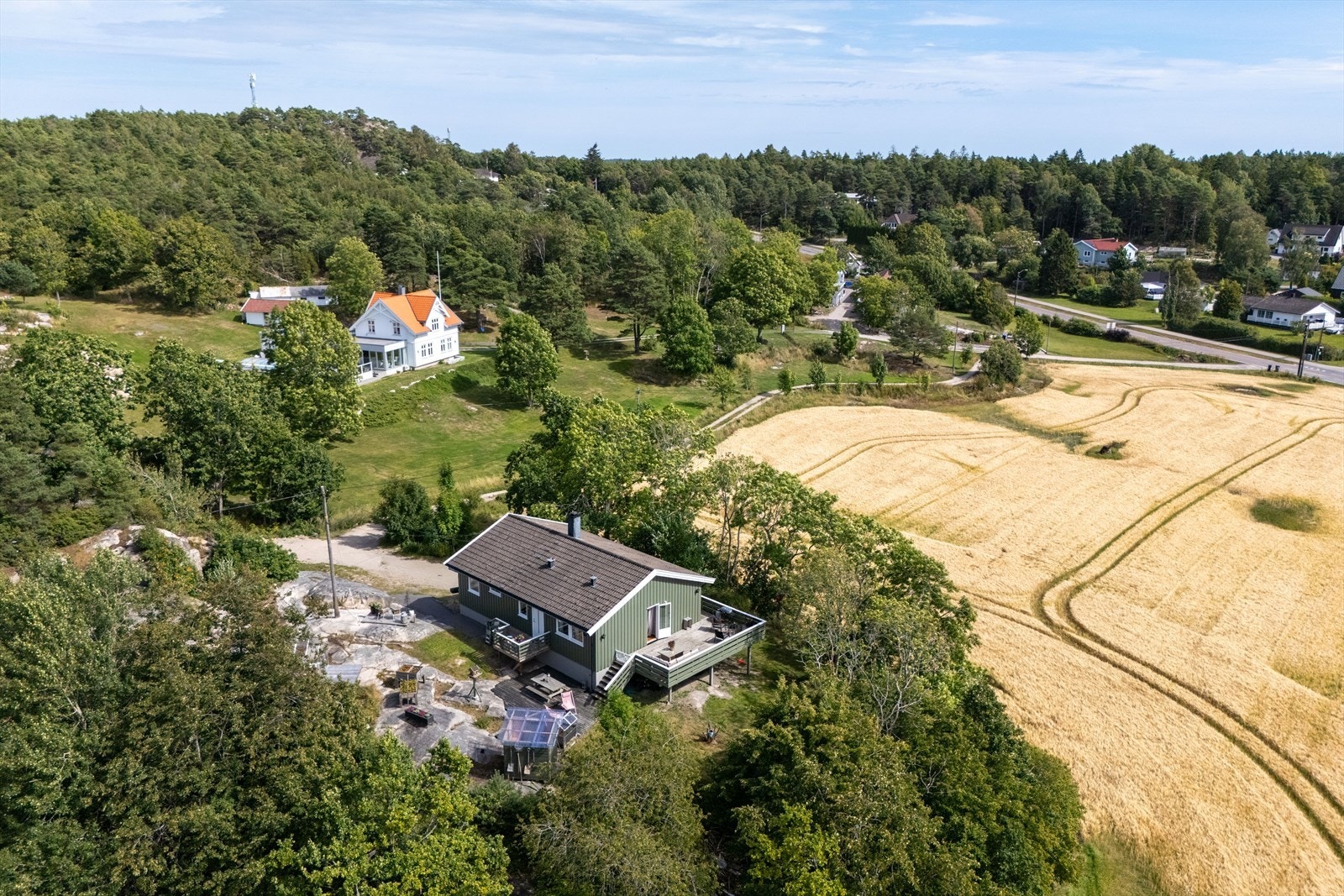 Den lange innkjørselen skjermer boligen godt fra veien og leder inn til en romslig gårdsplass med god plass til både biler og hobbyer. Galleribilde