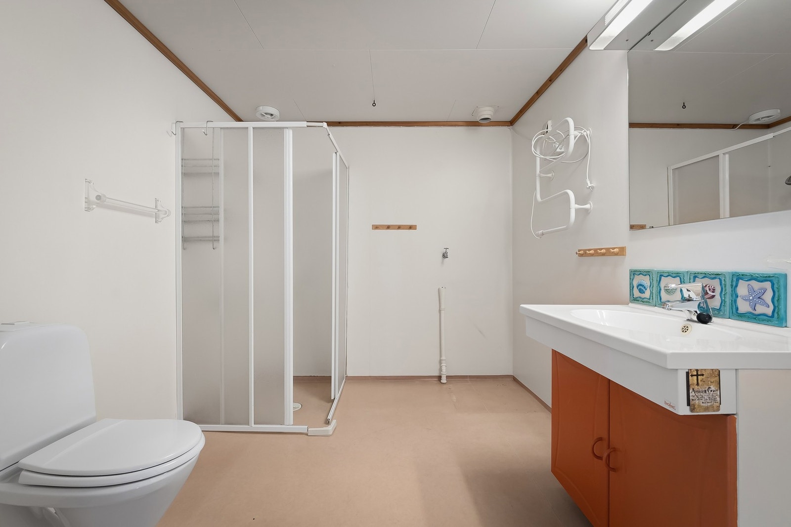 Svært romslig bad med vinylbelegg på gulv og elektriske varmekabler. Våtrommet har innredning med nedfelt servant, toalett, dusjvegger/hjørne og opplegg for vaskemaskin. Våtrommet har avtrekksventilasjon Galleribilde