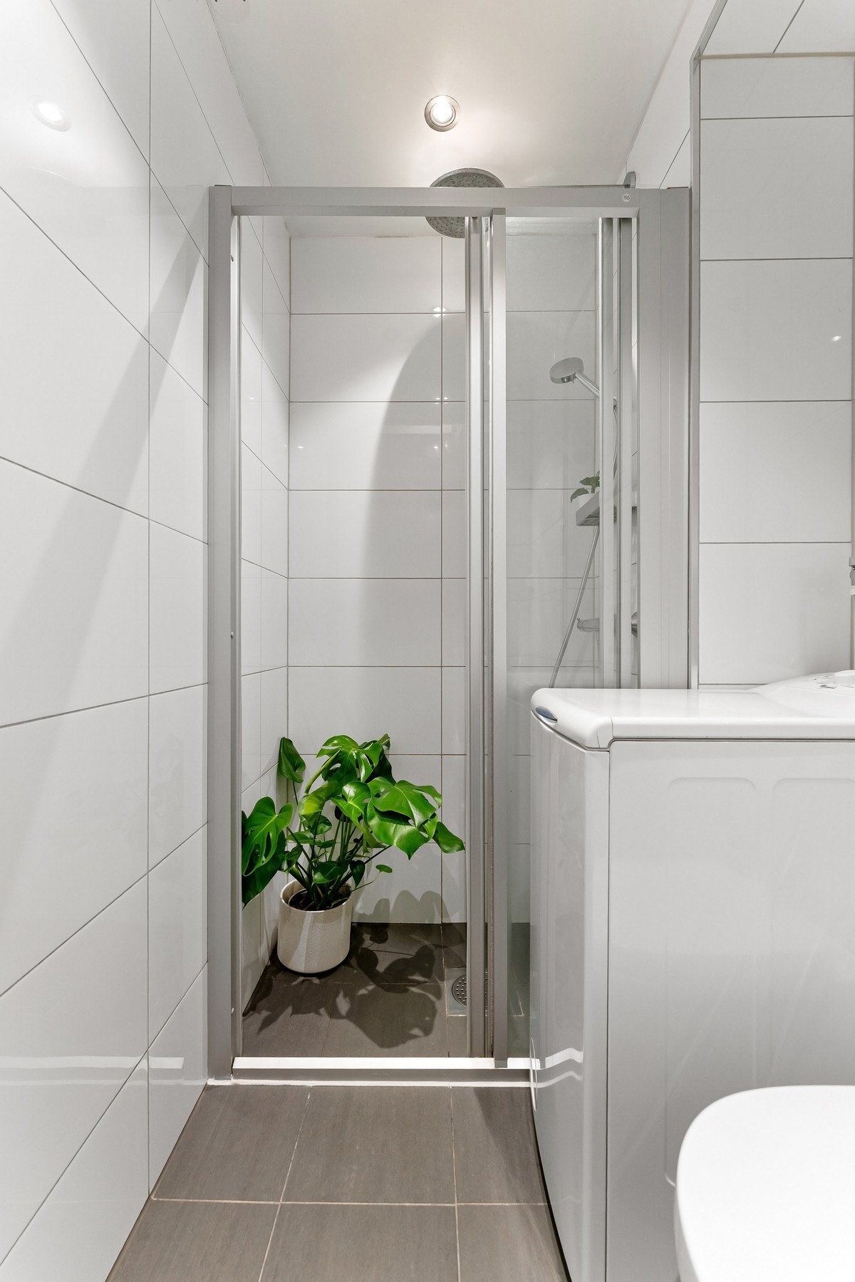 Badet er innredet med vegghengt toalett, dusjnisje, servantseksjon med skuffer og overskap med speilfronter. Galleribilde