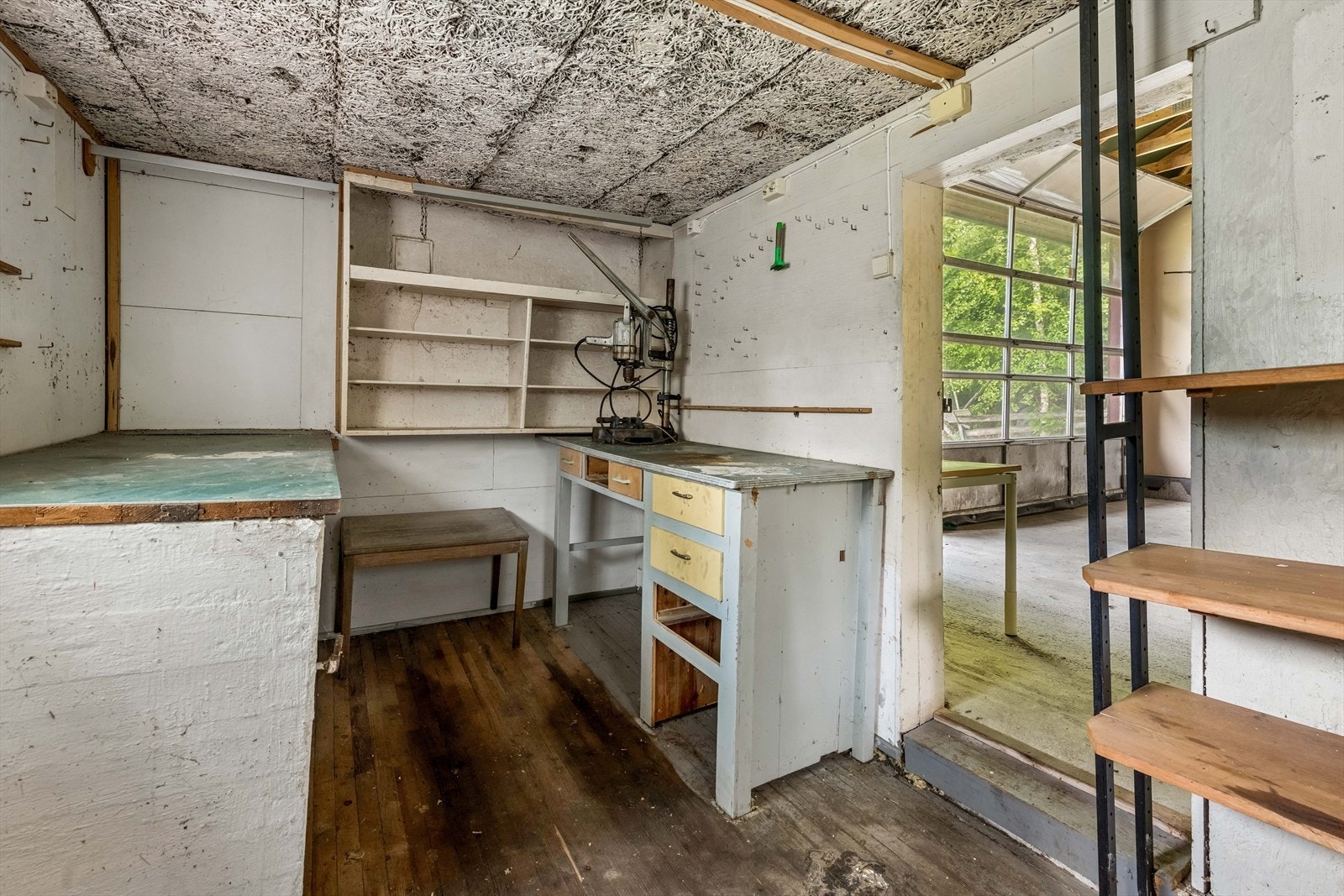 Innenfor garasjen er det verksted med hyller, benk, taklys og stikkontakter. Galleribilde
