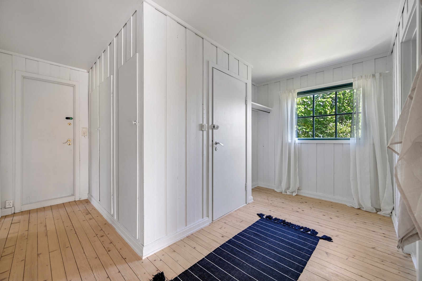 Romslig entré med plassbygget garderobe samt eget område for oppheng Galleribilde