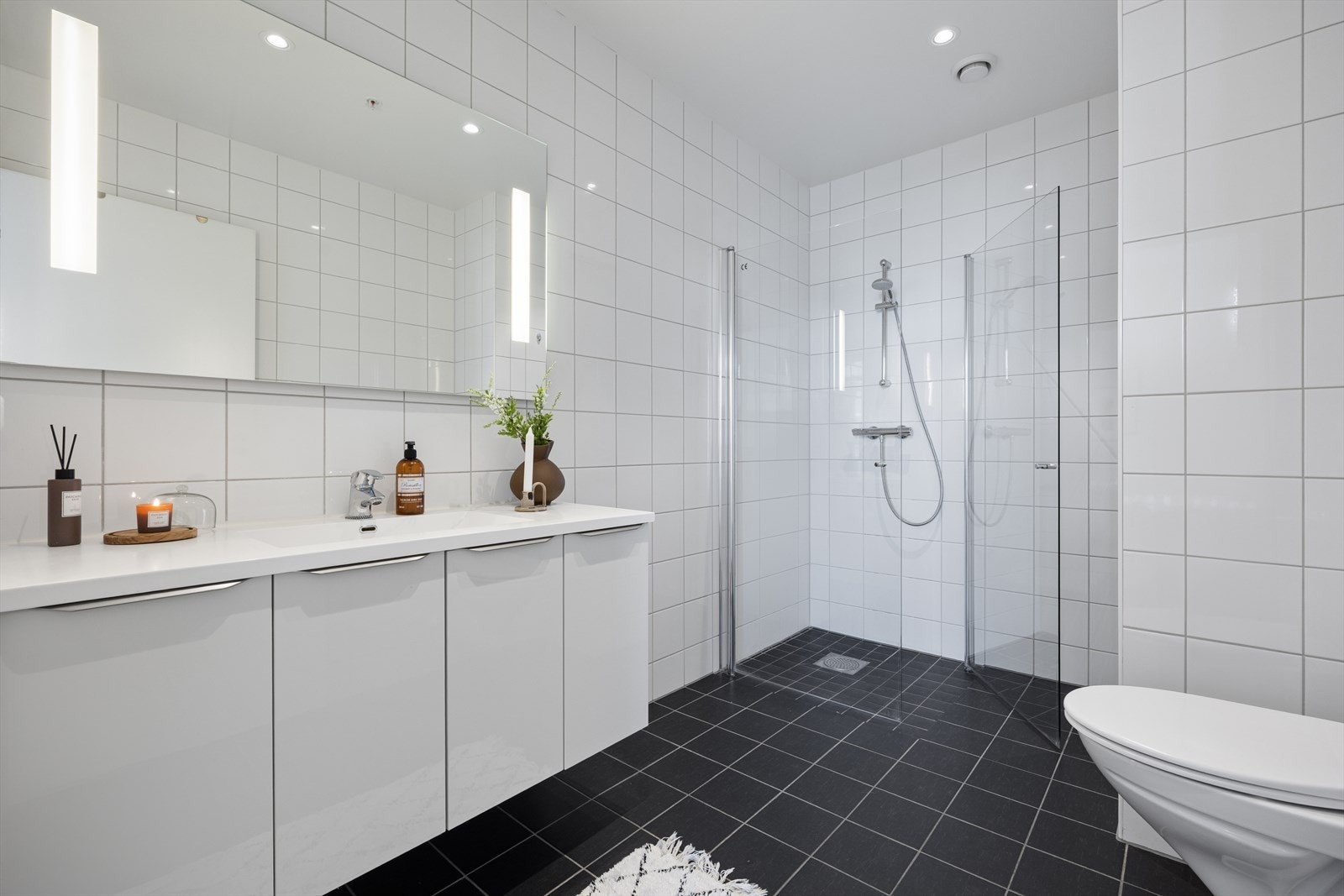 Hovedbadet har fliser på vegger og flislagt gulv med elektriske varmekabler. Innredning med nedfelt servant, veggmontert toalett og dusjvegger/hjørne. Malt innvendig tak. Galleribilde