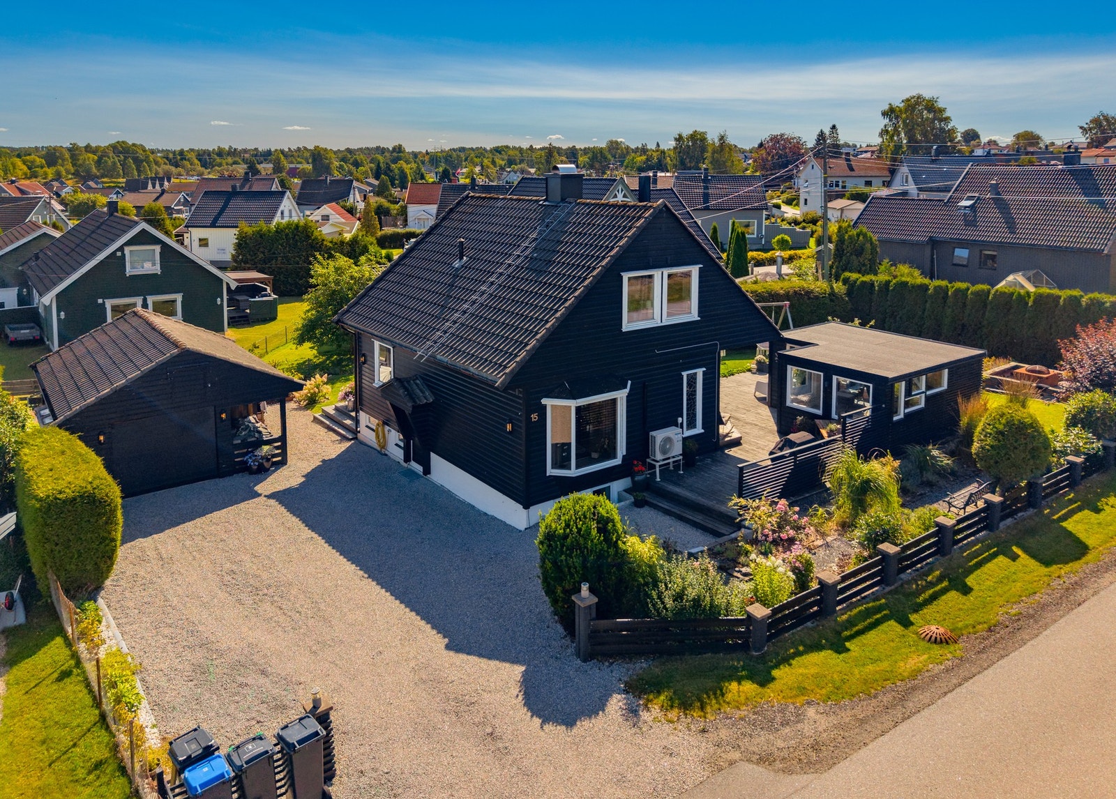 Stor, gruset gårdsplass og tilhørende garasje. Enkel adkomst for parkering, skjermet fra resten av tomten. Galleribilde