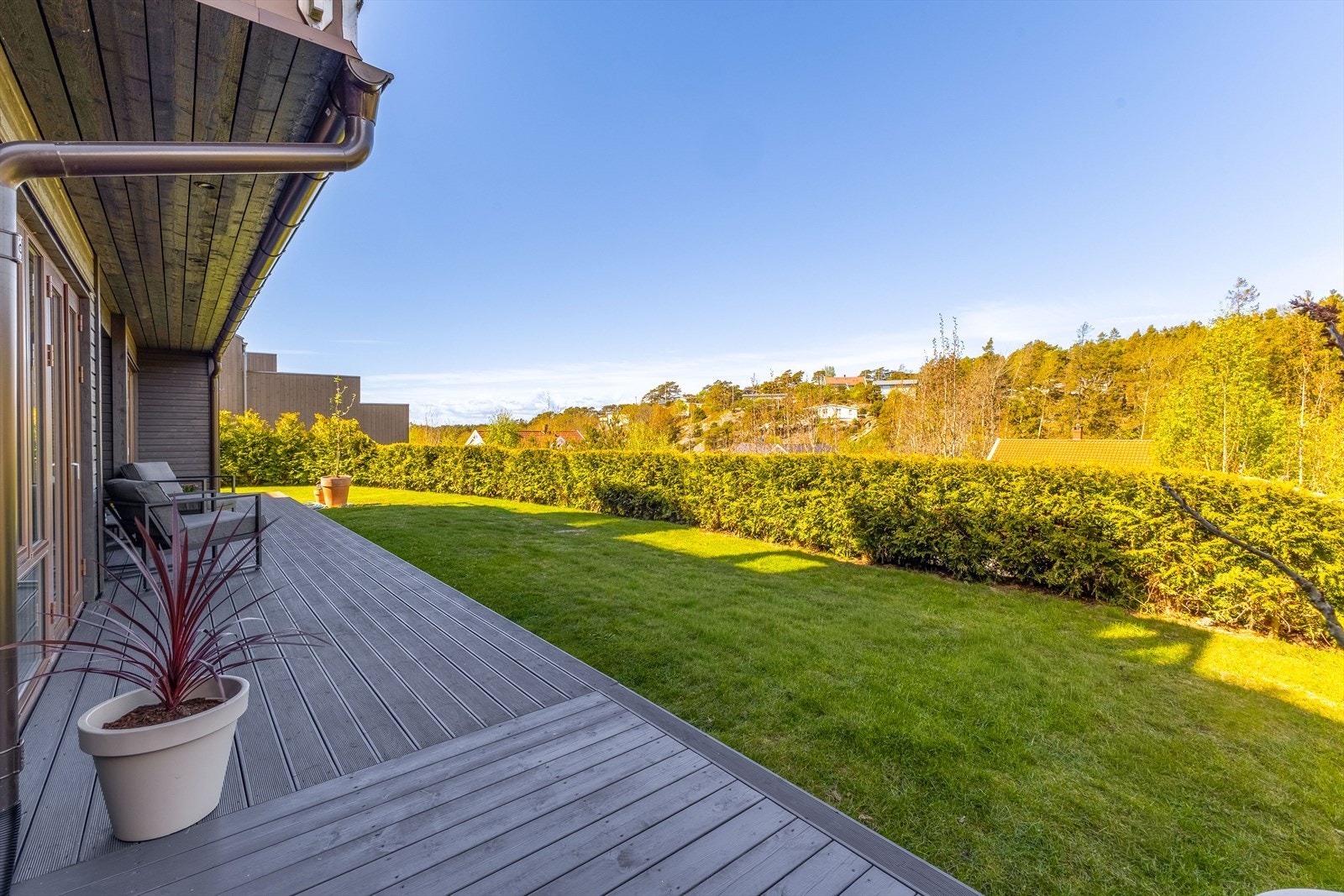 Boligen disponerer et pent opparbeidet uteområde med gressplen og hekk. Galleribilde