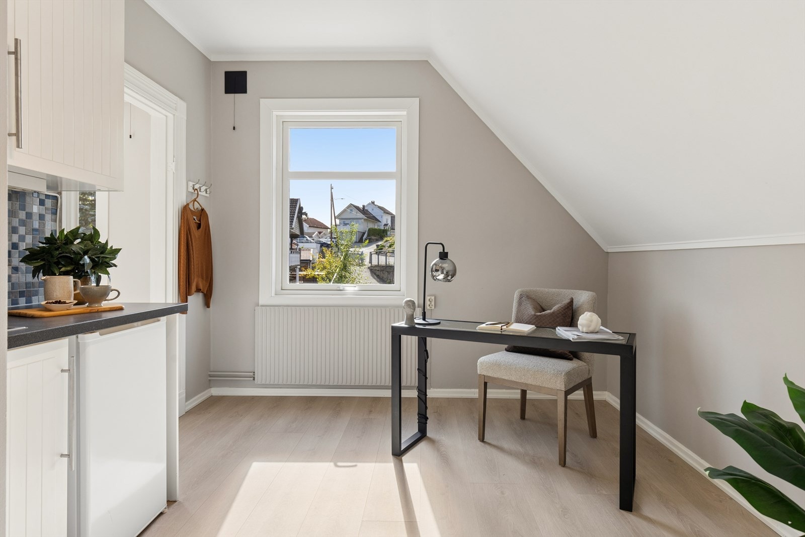 Enkel kjøkkeninnredning med profilerte fronter og laminatbenkeplate og en liten kjøkkenkum samt plass for lite kjøleskap. Galleribilde