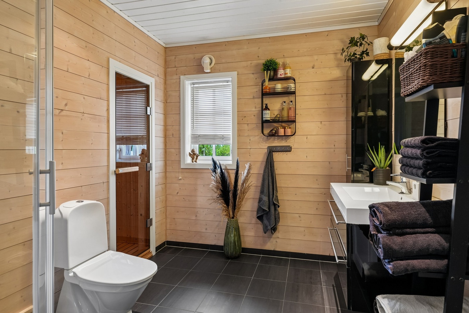 Flislagt gulv med varmekabler bidrar til god komfort, og fra badet er det direkte adkomst til en innbydende badstue. Galleribilde