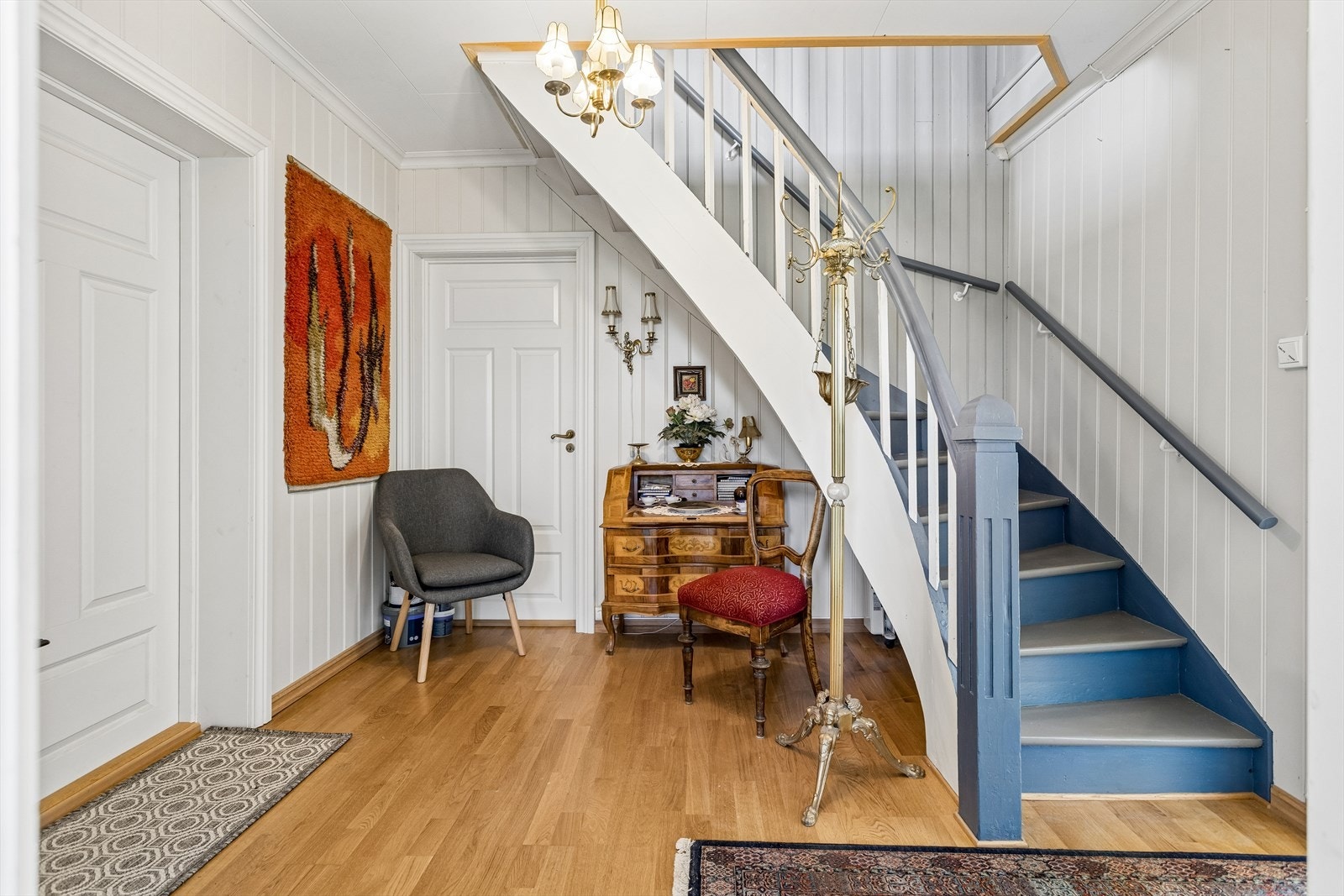 Hallen har en malt tretrapp som fører opp til andre etasje. Galleribilde