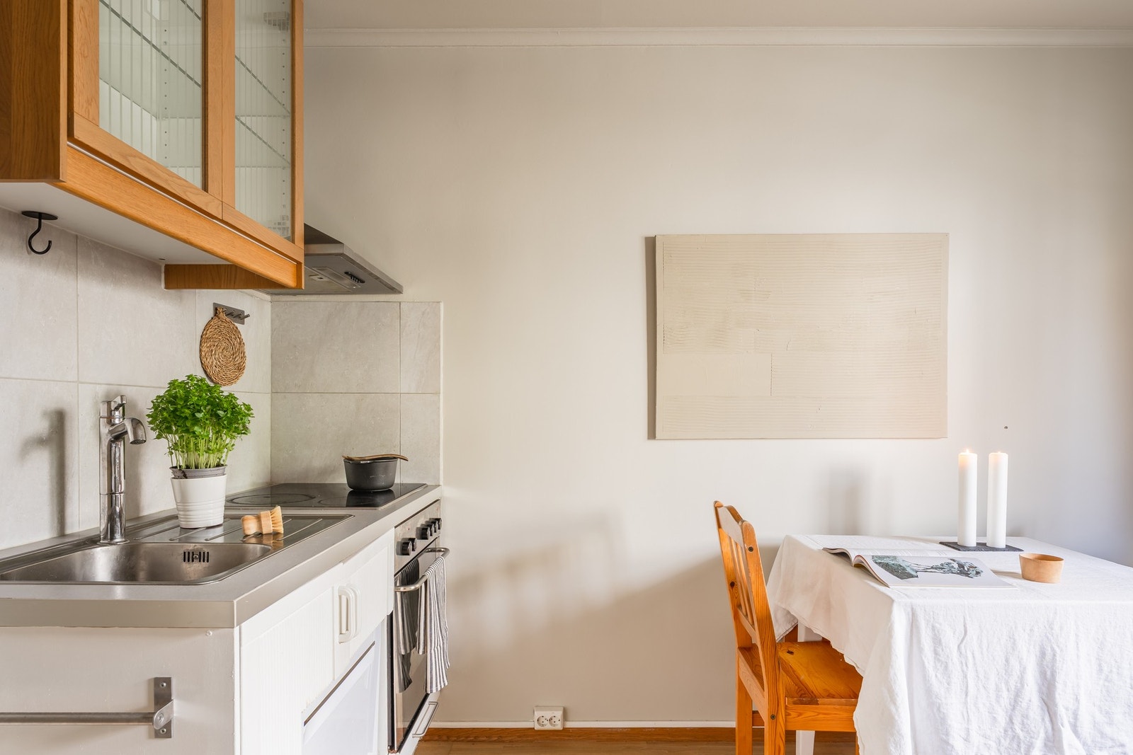 Stuen med åpen kjøkkenløsning med plass til sofa og lite spisebord. Galleribilde