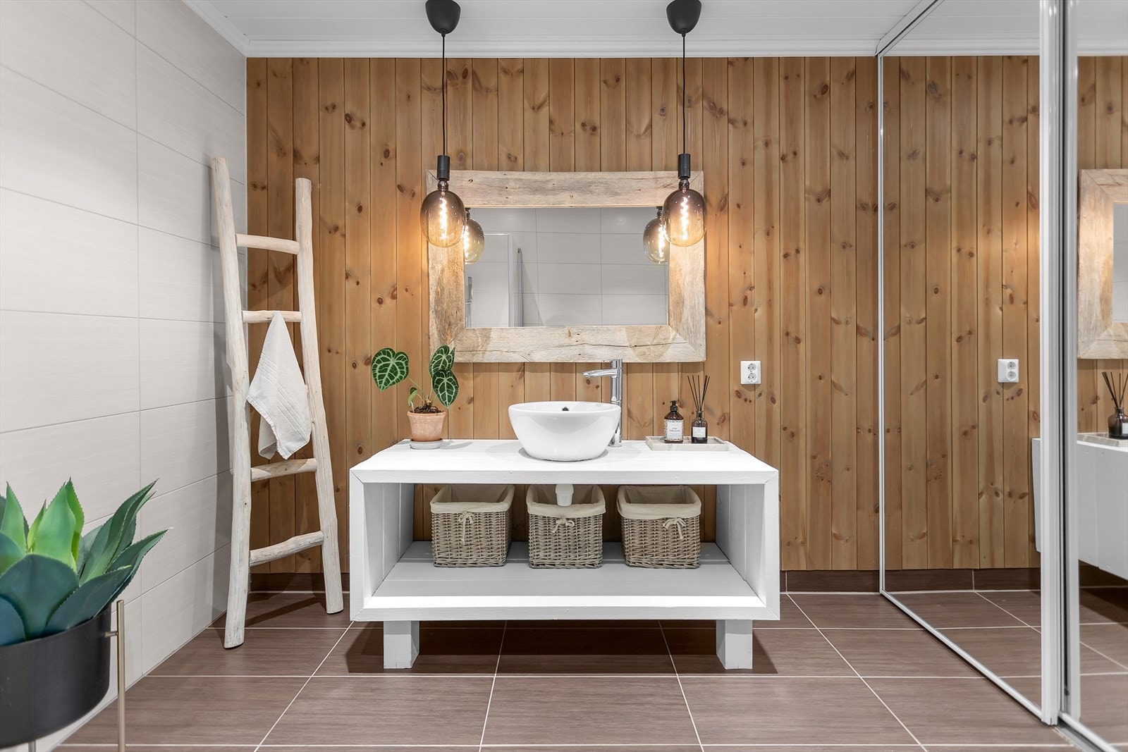 Badet fungerer også som et praktisk vaskerom med opplegg for vaskemaskin. Den integrerte skyvedørsgarderoben skjuler både vaskemaskinopplegget og garderobeløsningen, noe som gir et ryddig, moderne og svært funksjonelt uttrykk. Galleribilde