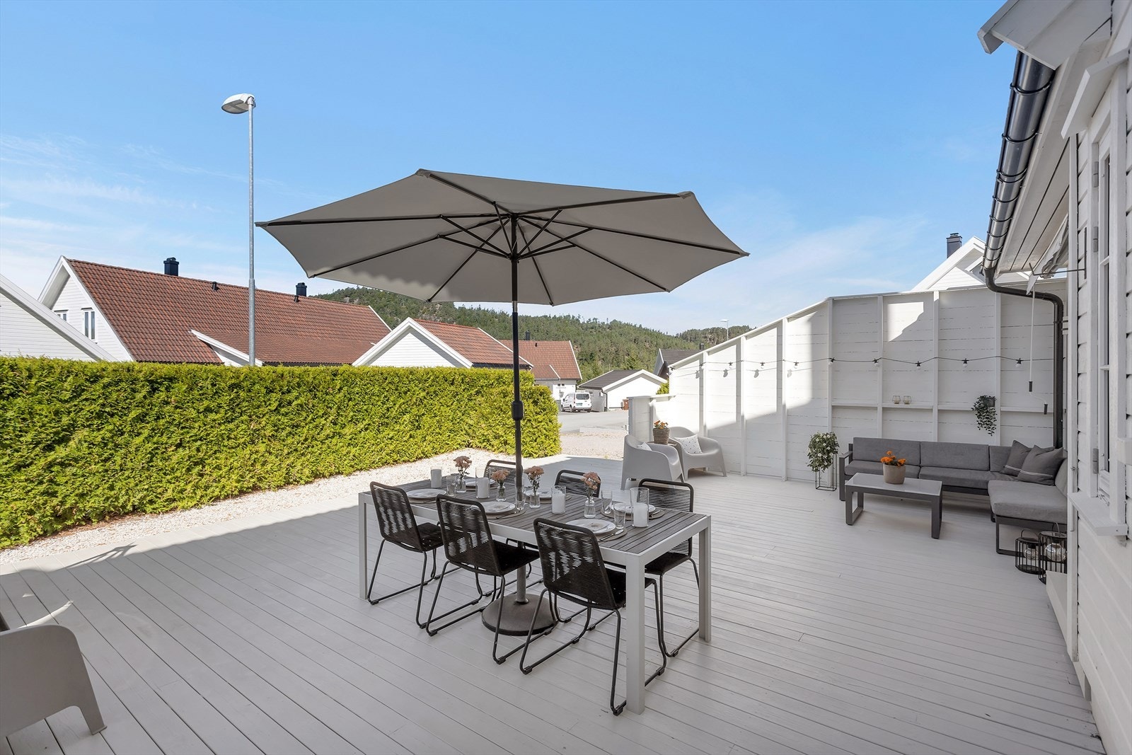 Den store uteplassen på fremsiden gir rikelig med plass til både spisegruppe og loungegruppe, og skaper et fleksibelt og innbydende uterom som kan nytes gjennom hele sesongen. Galleribilde