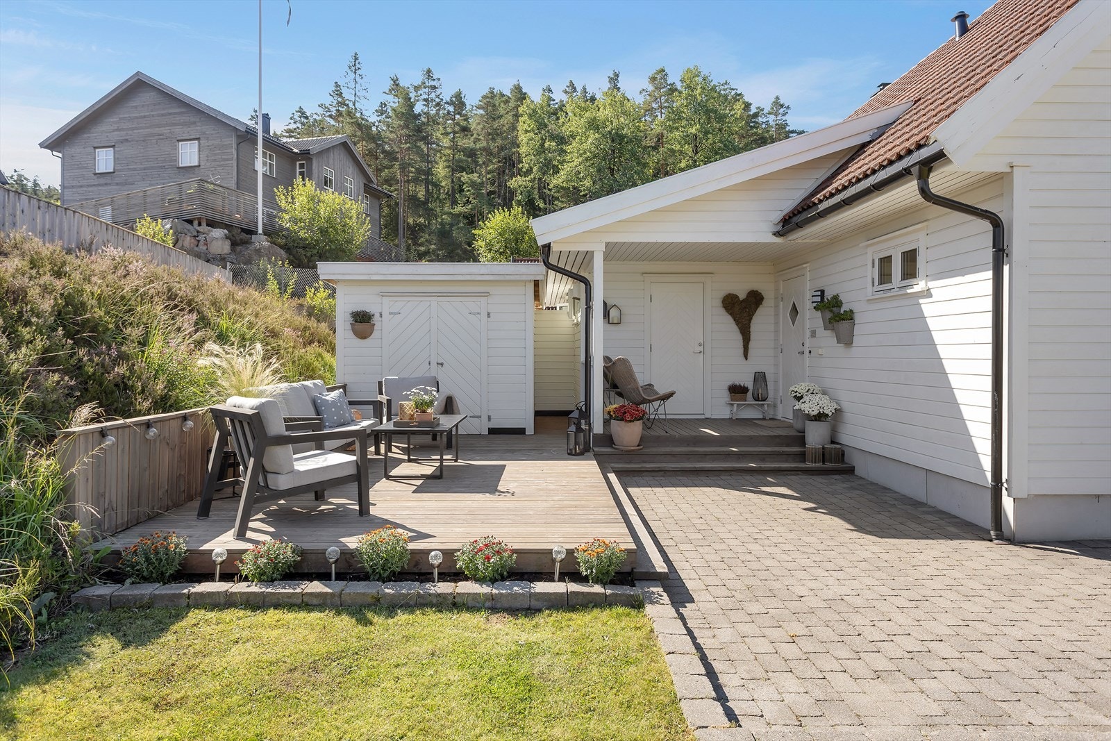 Overbygget inngangsparti og en platting på ca. 29 m² ønsker velkommen, og gir et innbydende førsteinntrykk med god plass til hyggelige uteaktiviteter. Galleribilde