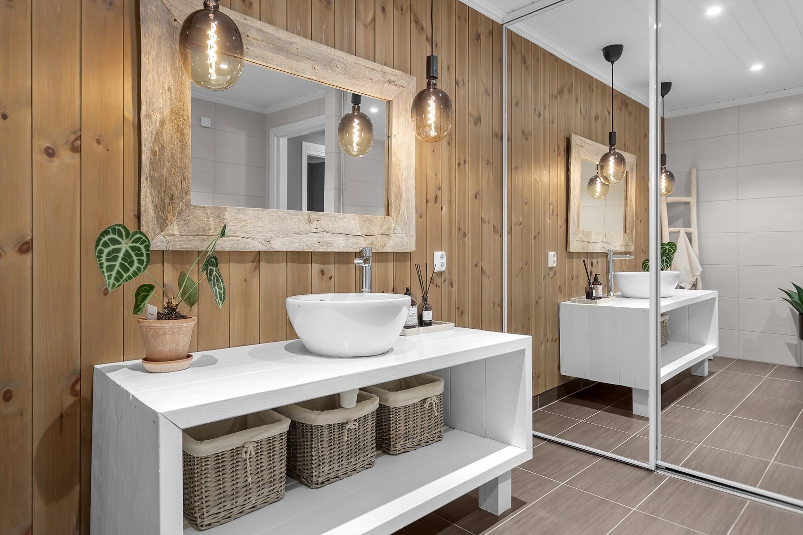 Badet i første etasje fremstår som tiltalende, moderne og praktisk, med fliser på både gulv og vegger samt panel som tilfører et stilfullt og gjennomført inntrykk. Galleribilde