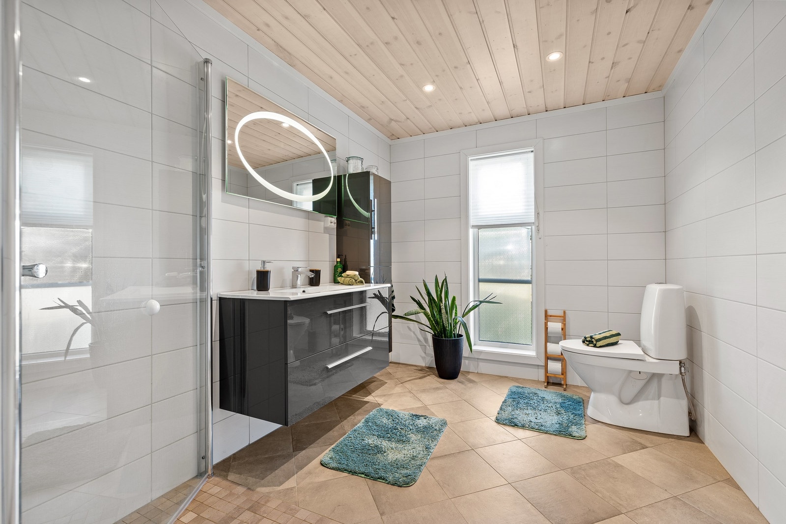 Badet har toalett, downlights og gulvvarme, samt servant med skuffer og et speil med integrert belysning. Galleribilde