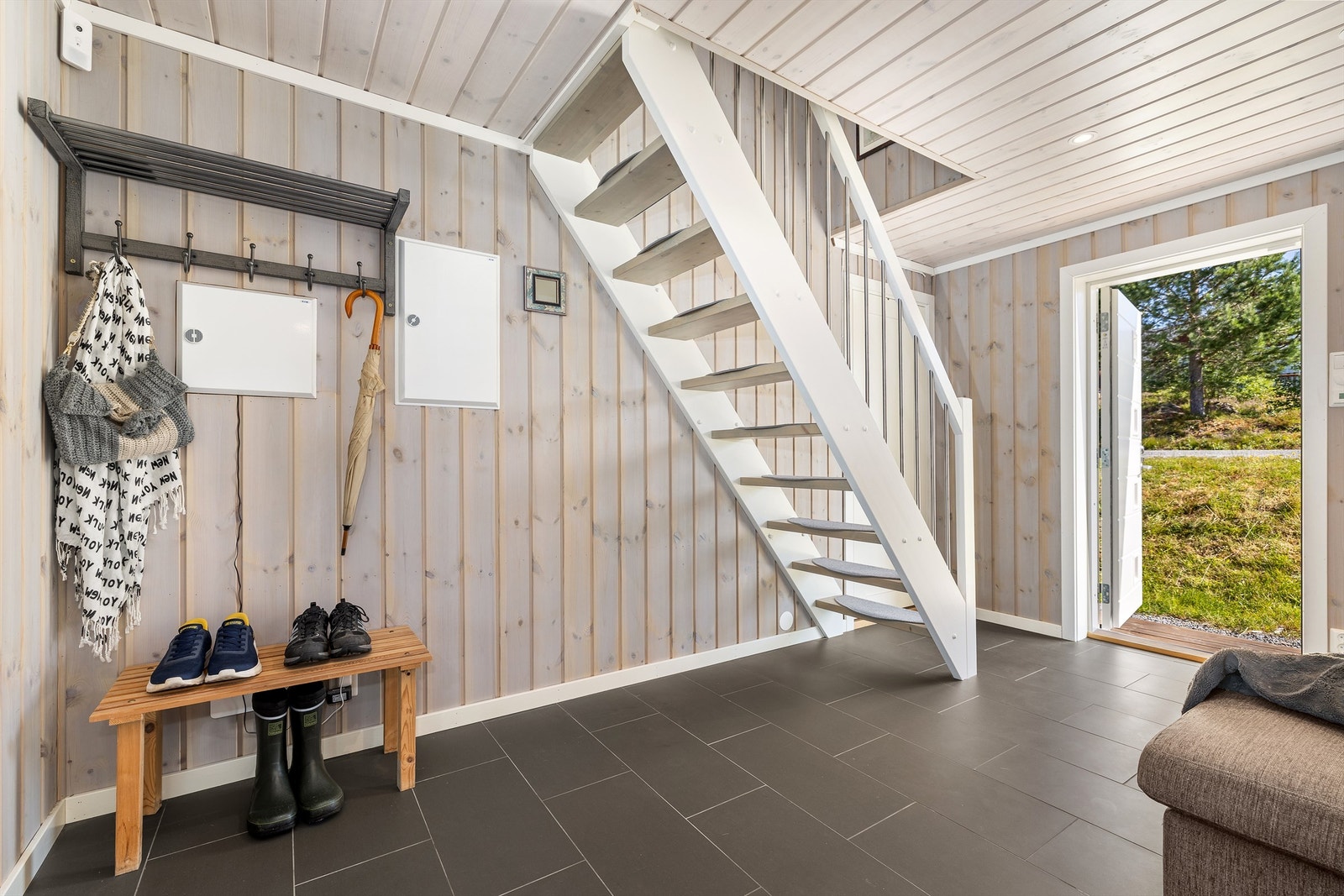 Vel inne har hytta en bred entré med downlights, varmekabler og fliser på gulvet. Galleribilde