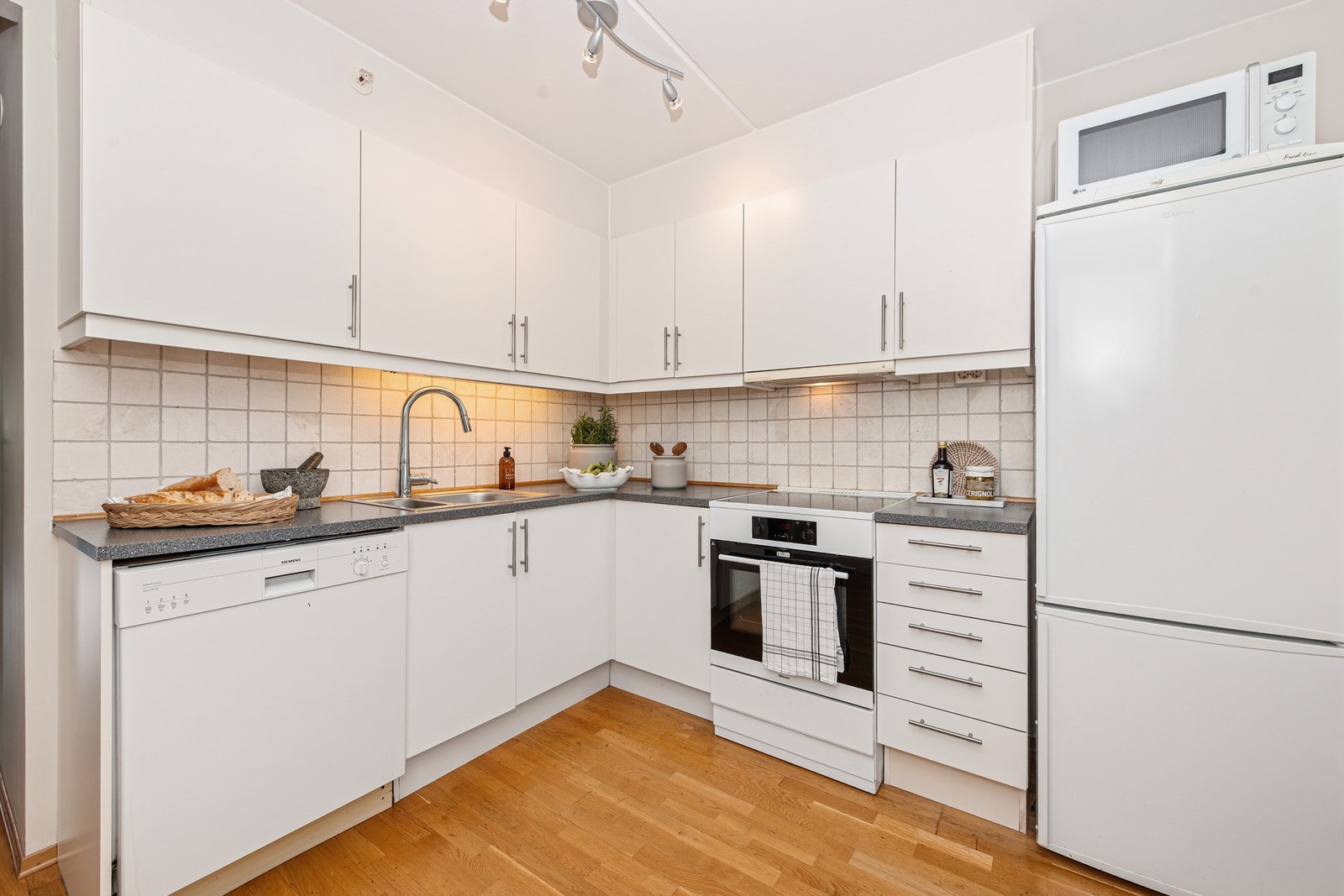 Kjøkkeneinnredning fra Norema med lyse, slette fronter kombinert med laminert benkeplate Galleribilde