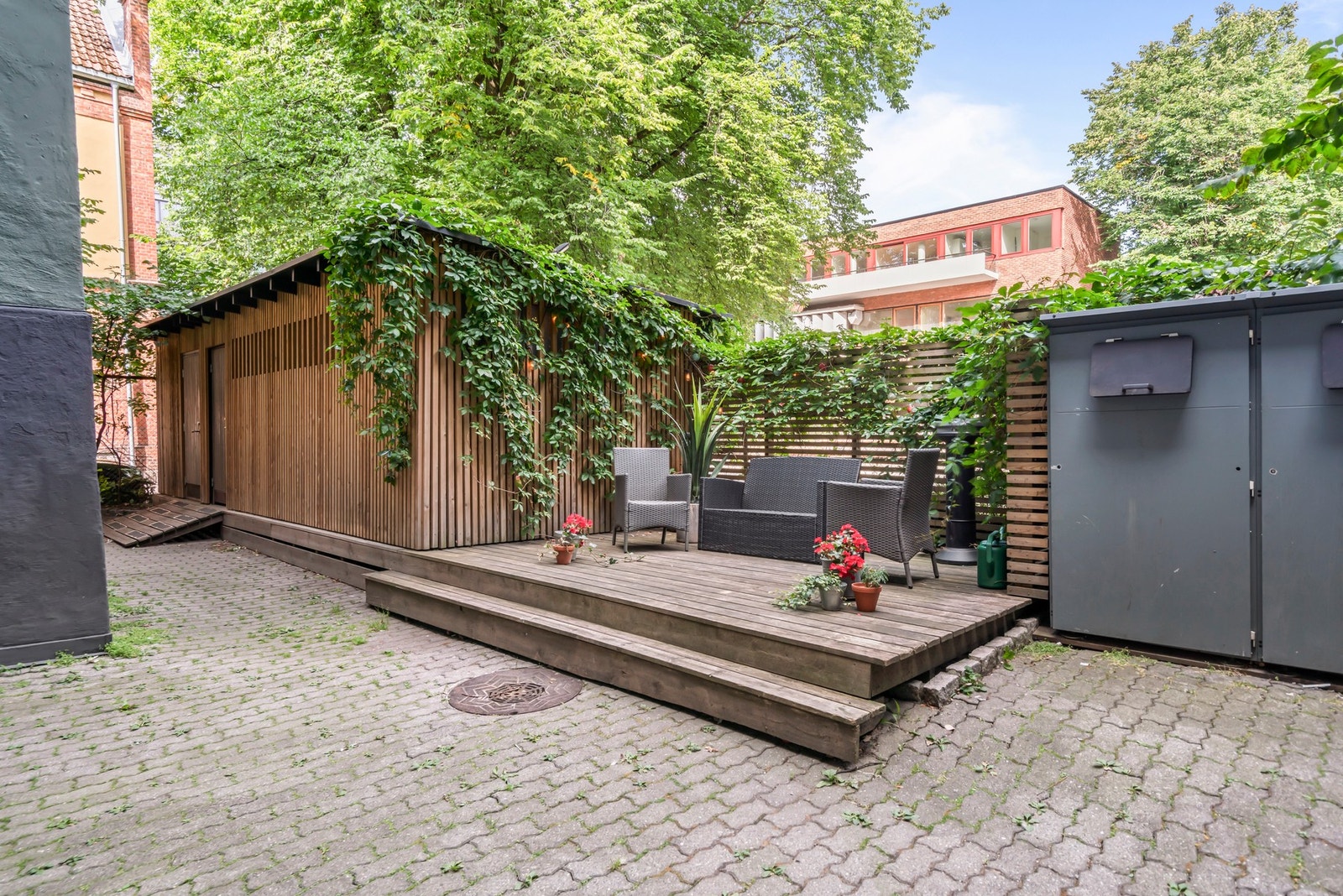 Hyggelig og frodig bakgård med sittegrupper og egen utebod for barneutstyr (barnevogn og leker) Galleribilde