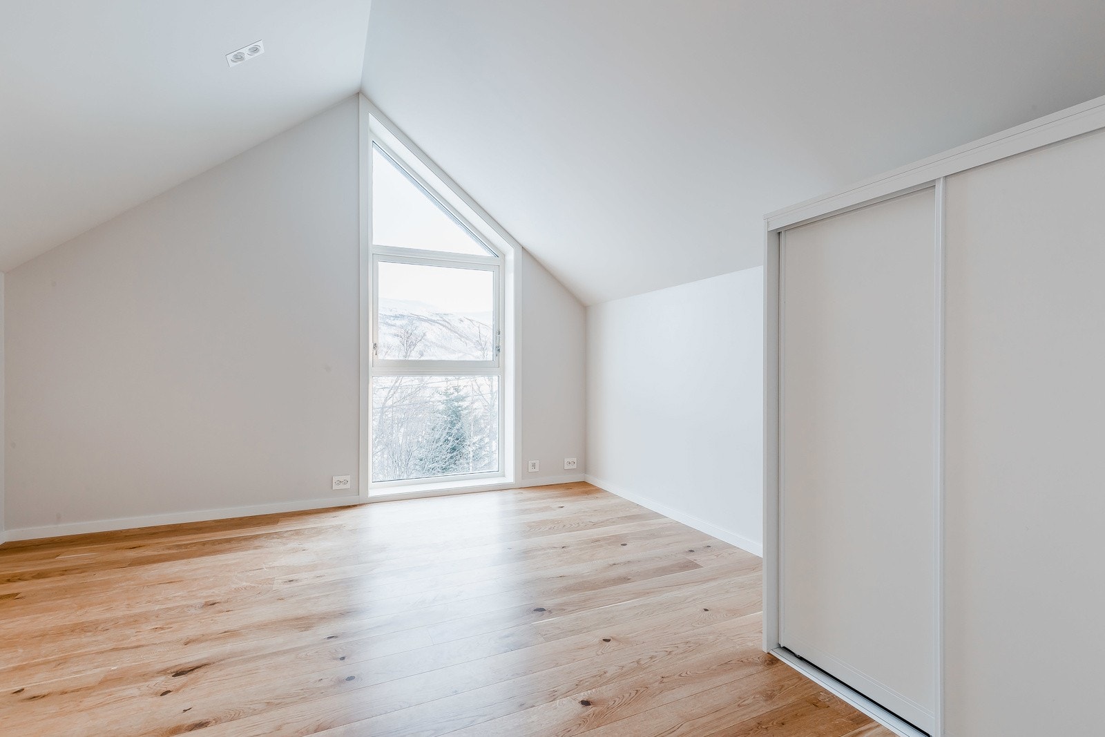 Soverom loft med skyvedørsgarderobe.