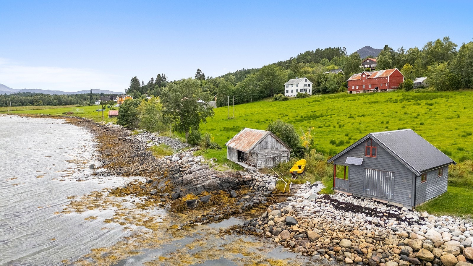 Sjarmerende småbruk med naust, fjordutsikt og historiske bygninger i vakre kystomgivelser på Frei Galleribilde