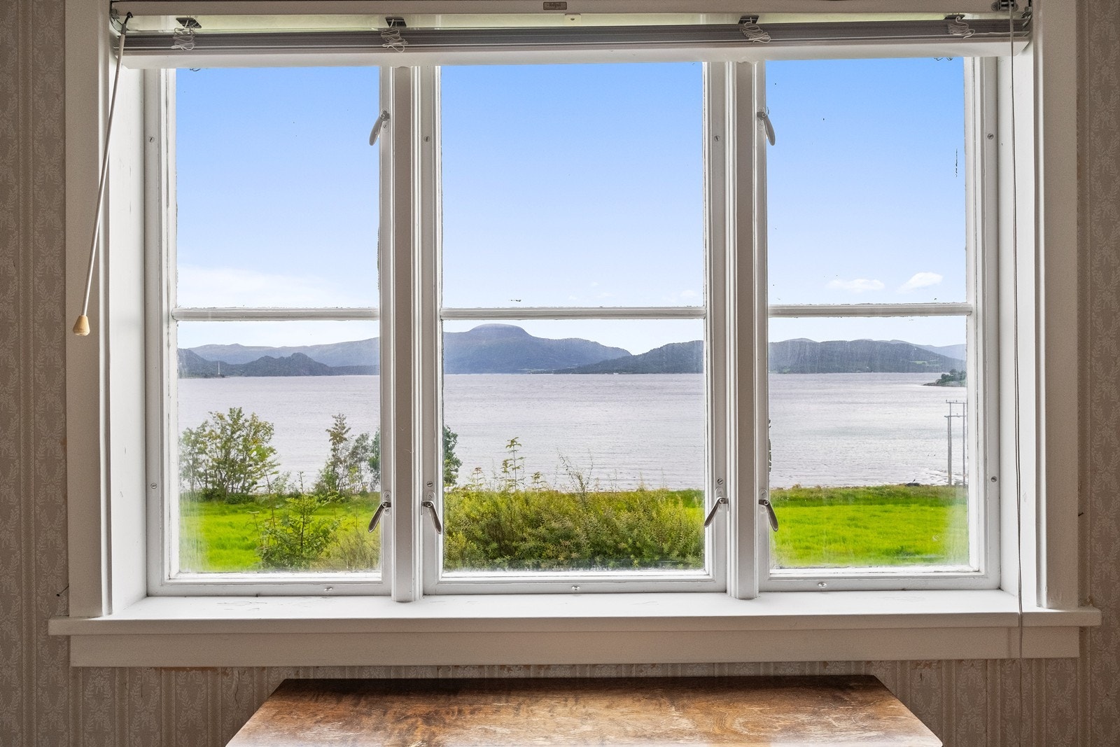 Fra stuevinduet ser man over fjorden til blant annet Reinsfjellet og Varden på Bergsøya Galleribilde