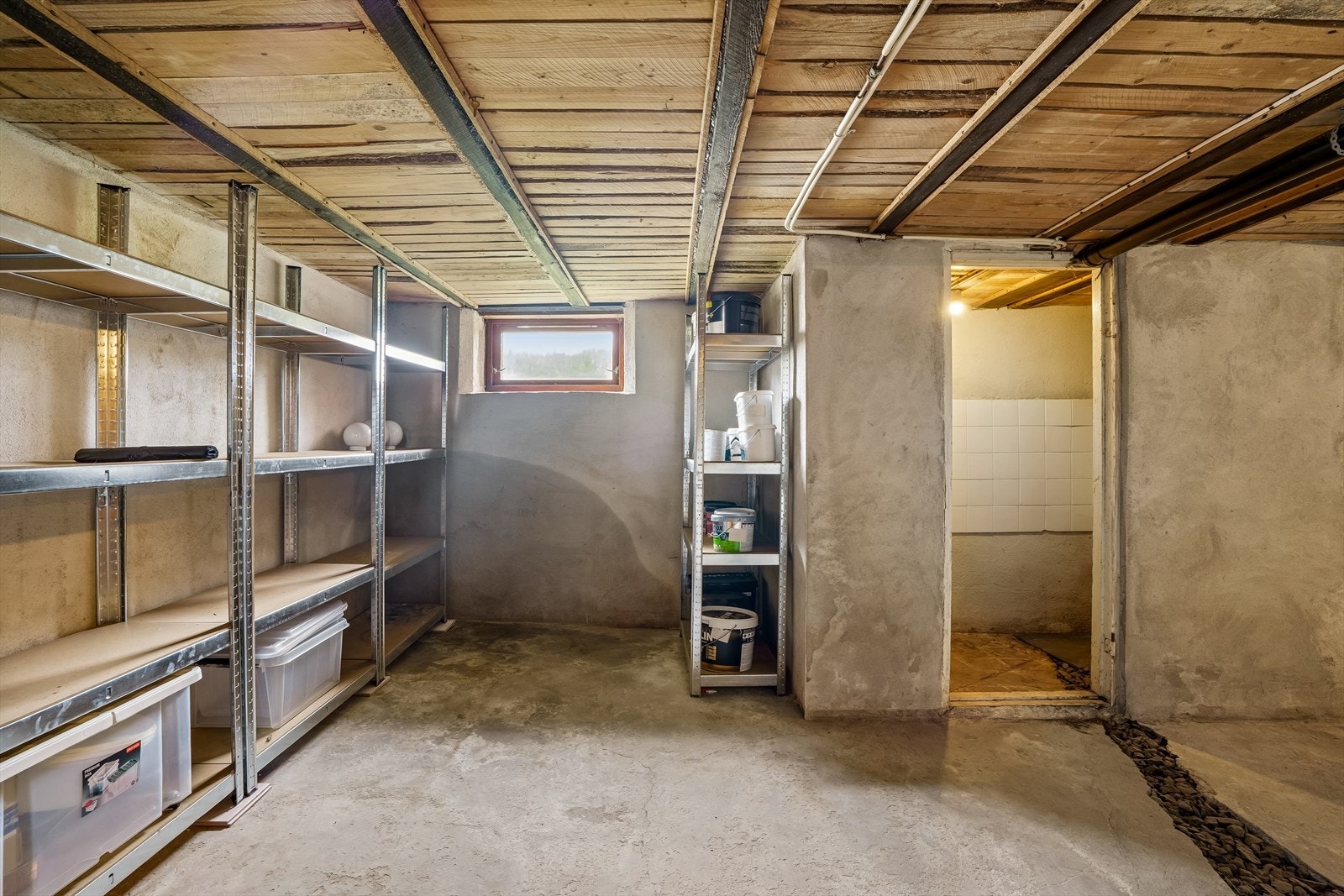 Kjelleren har betonggulv og et gulvareal på ca. 48 m² fordelt på fire rom, ideelt for lagring. Galleribilde