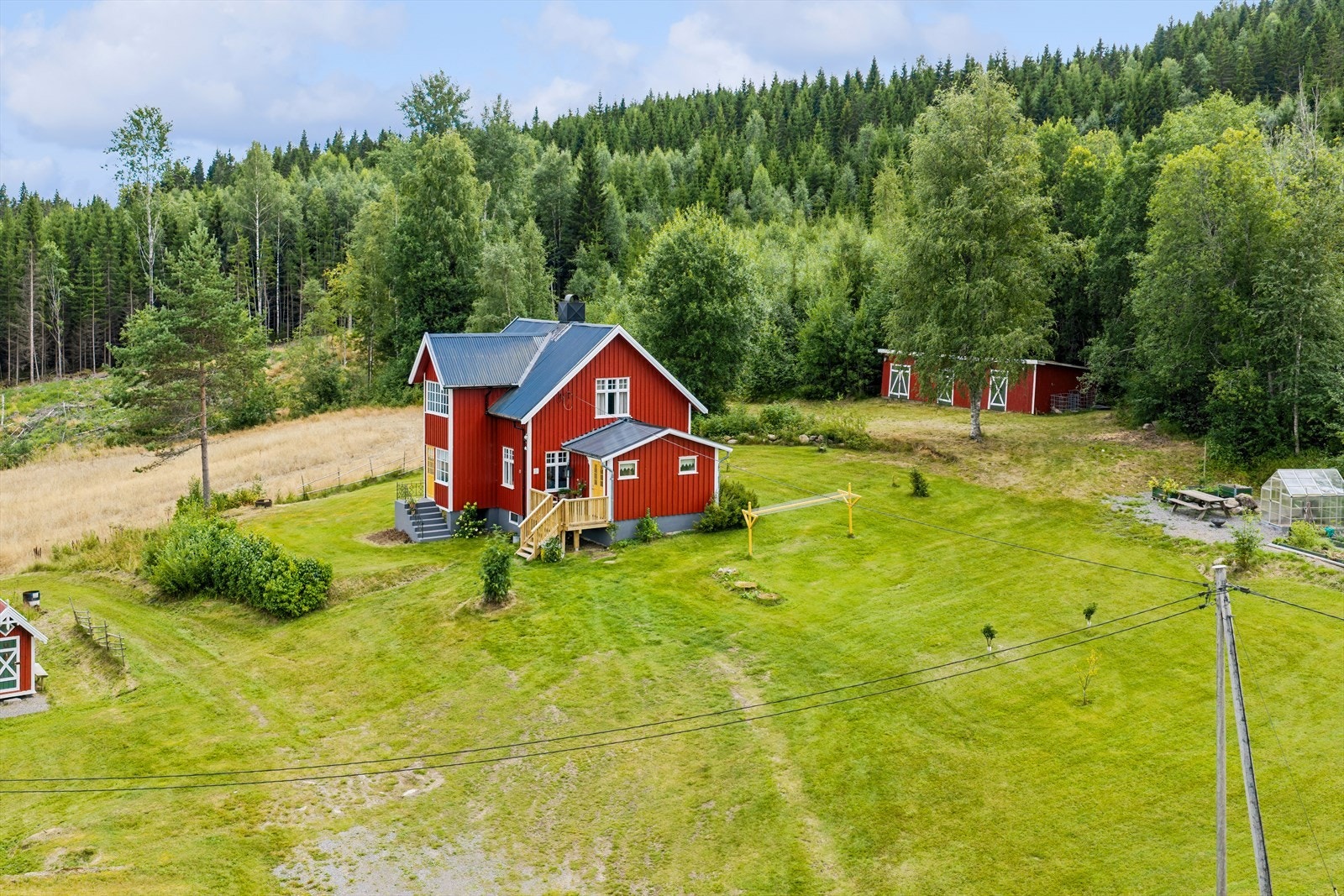 Oversikt over tunet med våningshus, låve, uthus og hundehus. Galleribilde