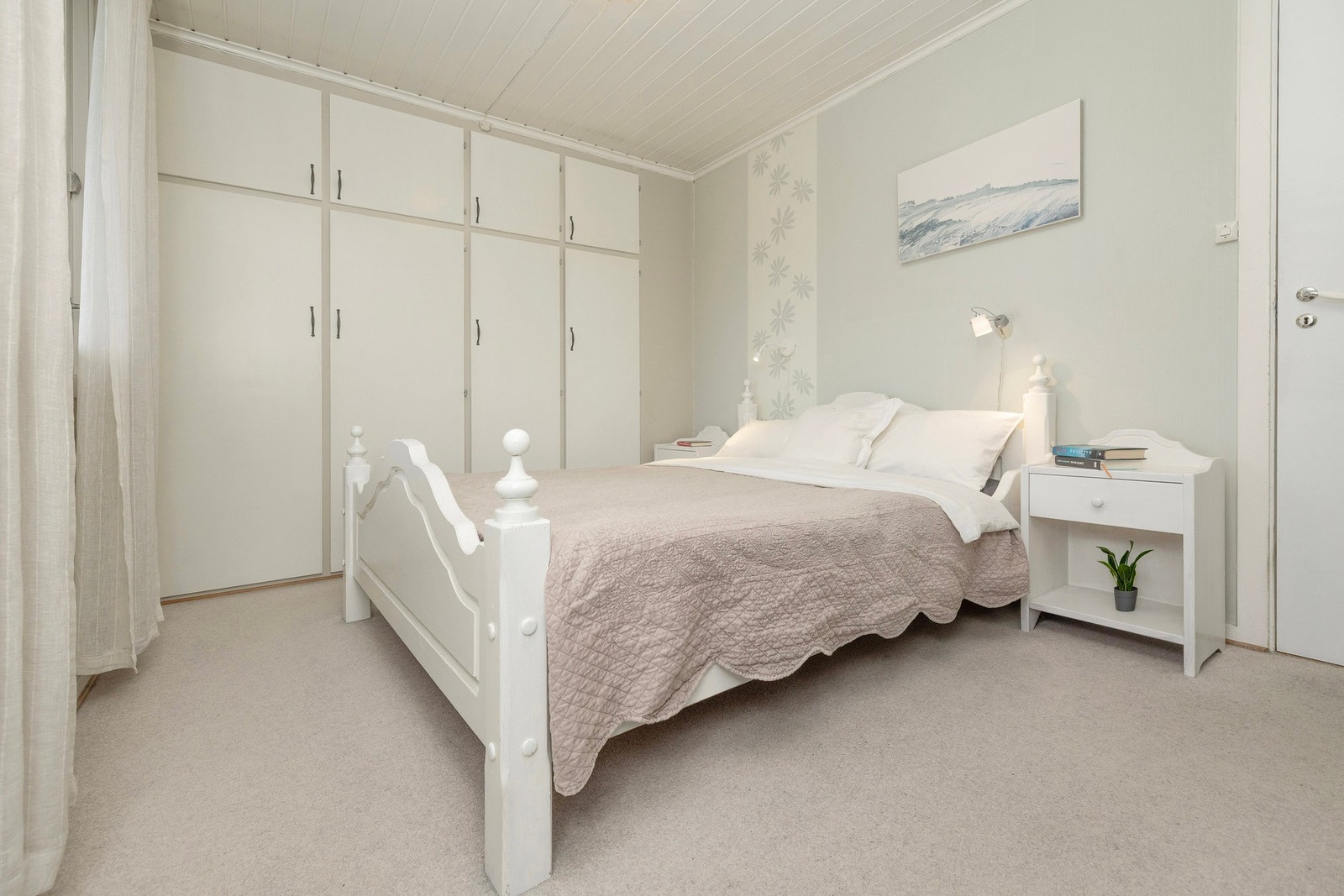 Romslig hovedsoverom med innebygde garderobeskap. Rommet har utgang til veranda på boligens fremside. Galleribilde