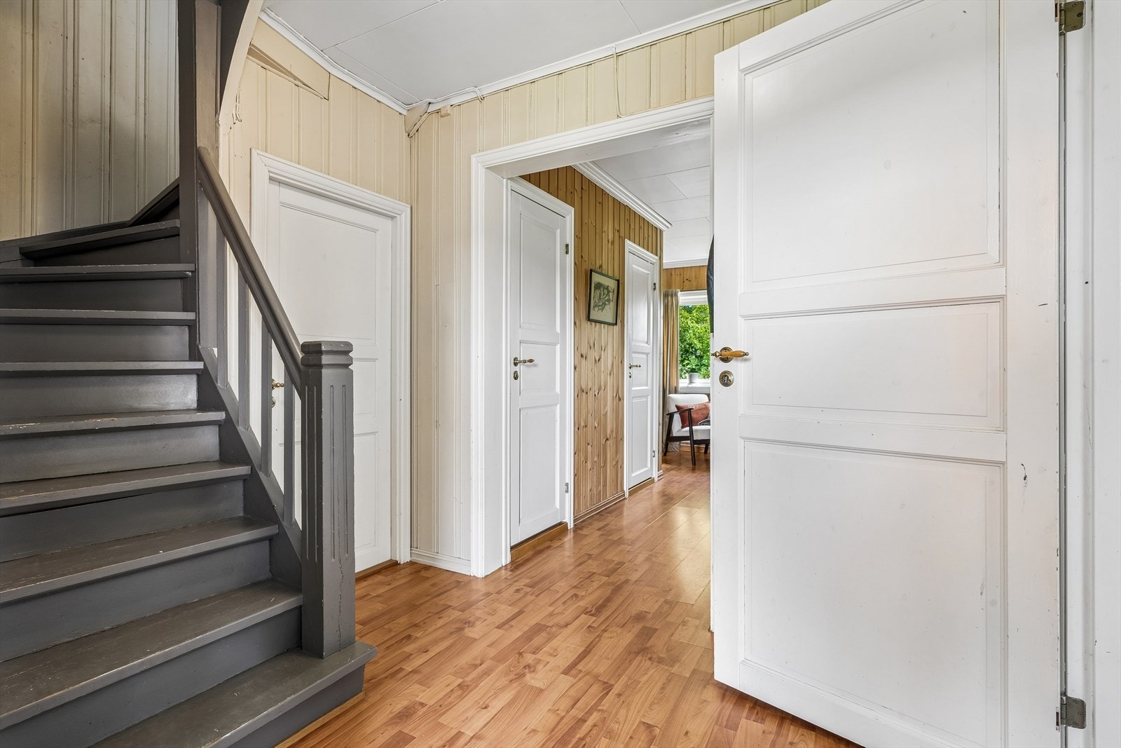 Malt tretrapp med rekkverk på én side leder opp til andre etasje. Galleribilde