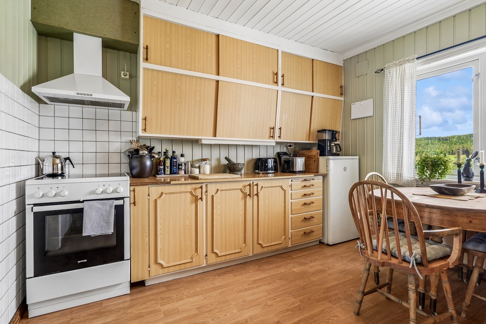 Fliser på veggen ved komfyren og mellom deler av benk og overskap. Galleribilde